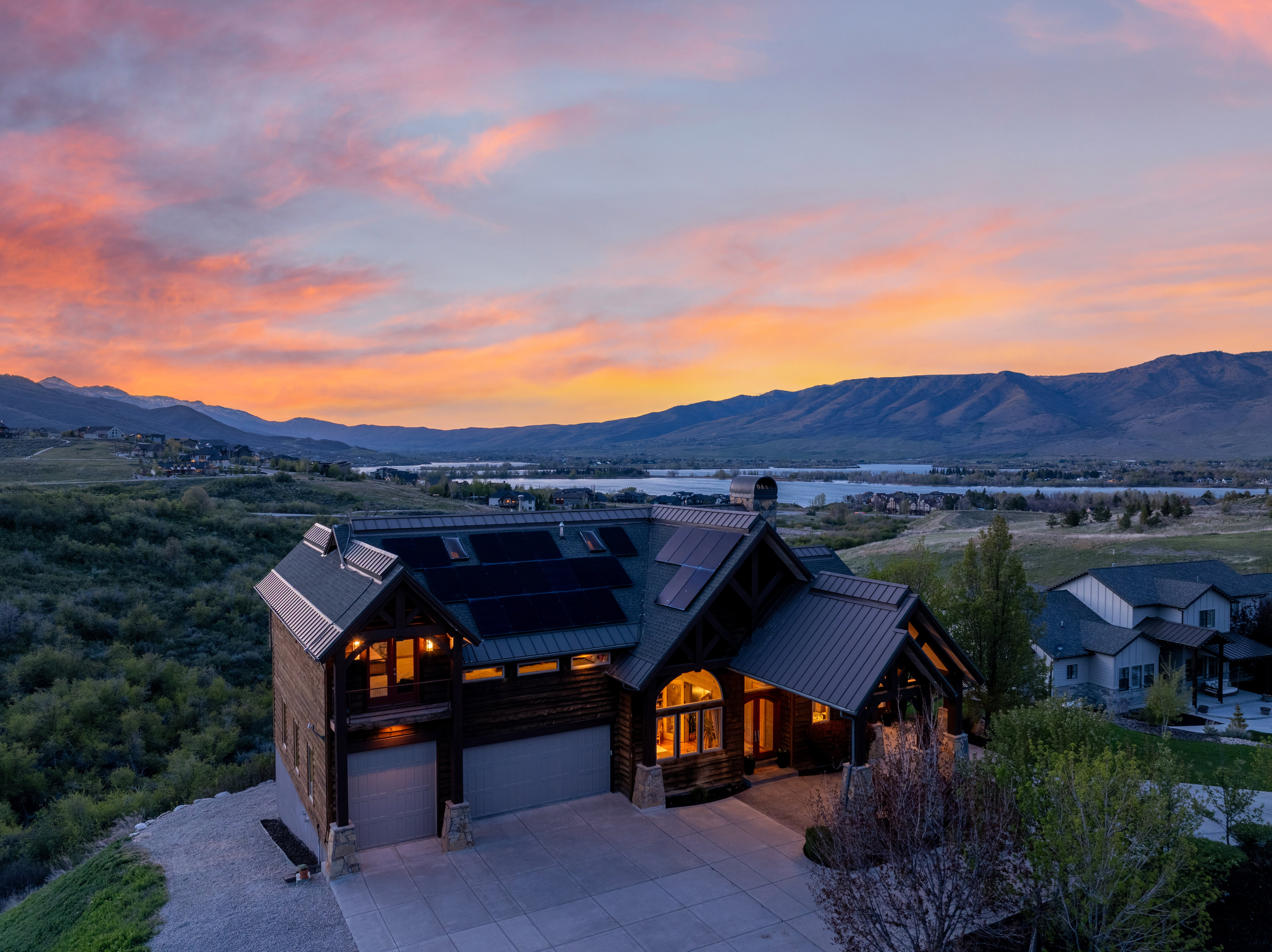 Crafted modern residence featuring a prominent metal roof, integrated solar panels, and a two-car garage