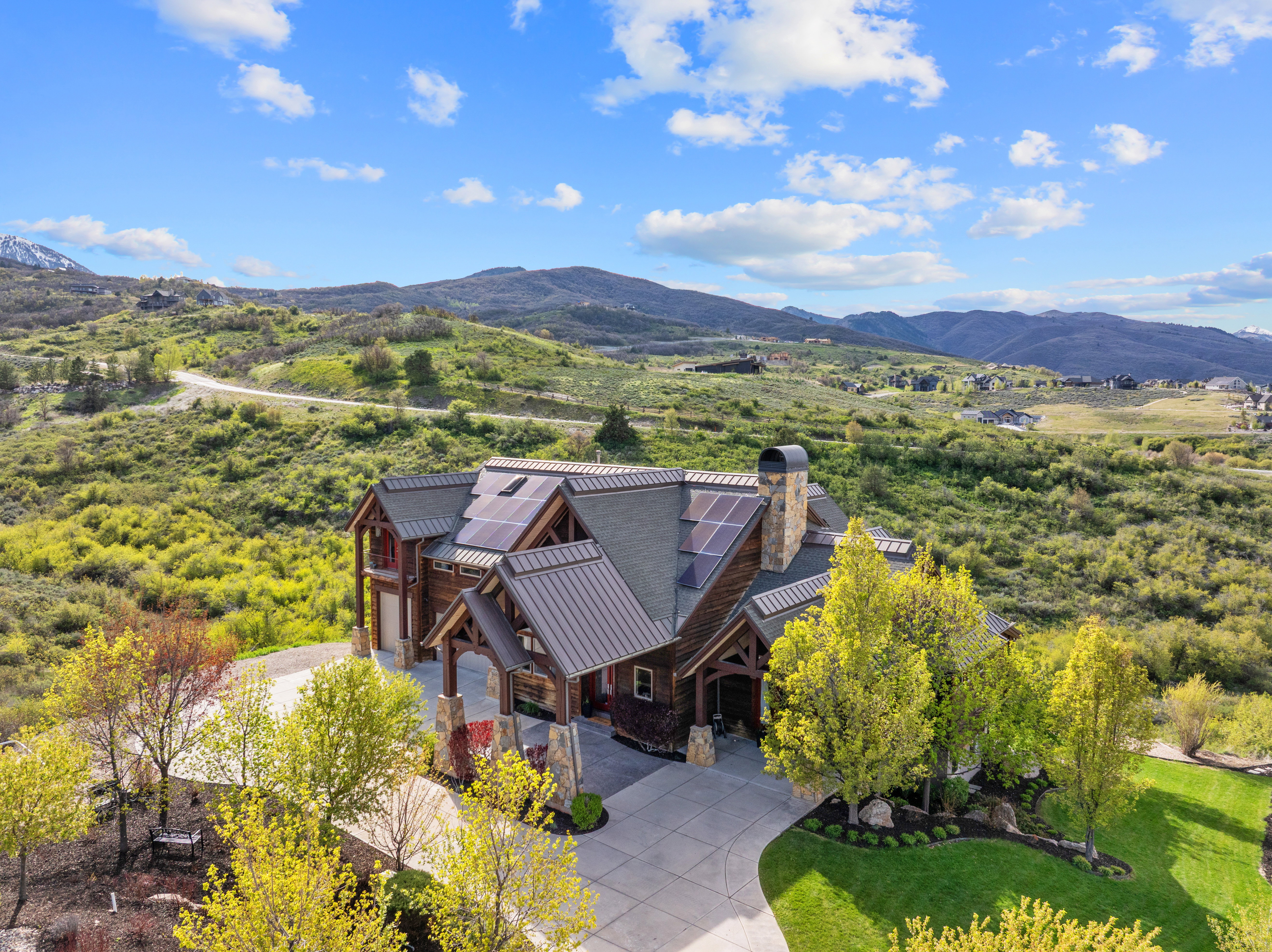 Expansive timber-frame residence featuring multiple gables, a metal roof, and solar panels