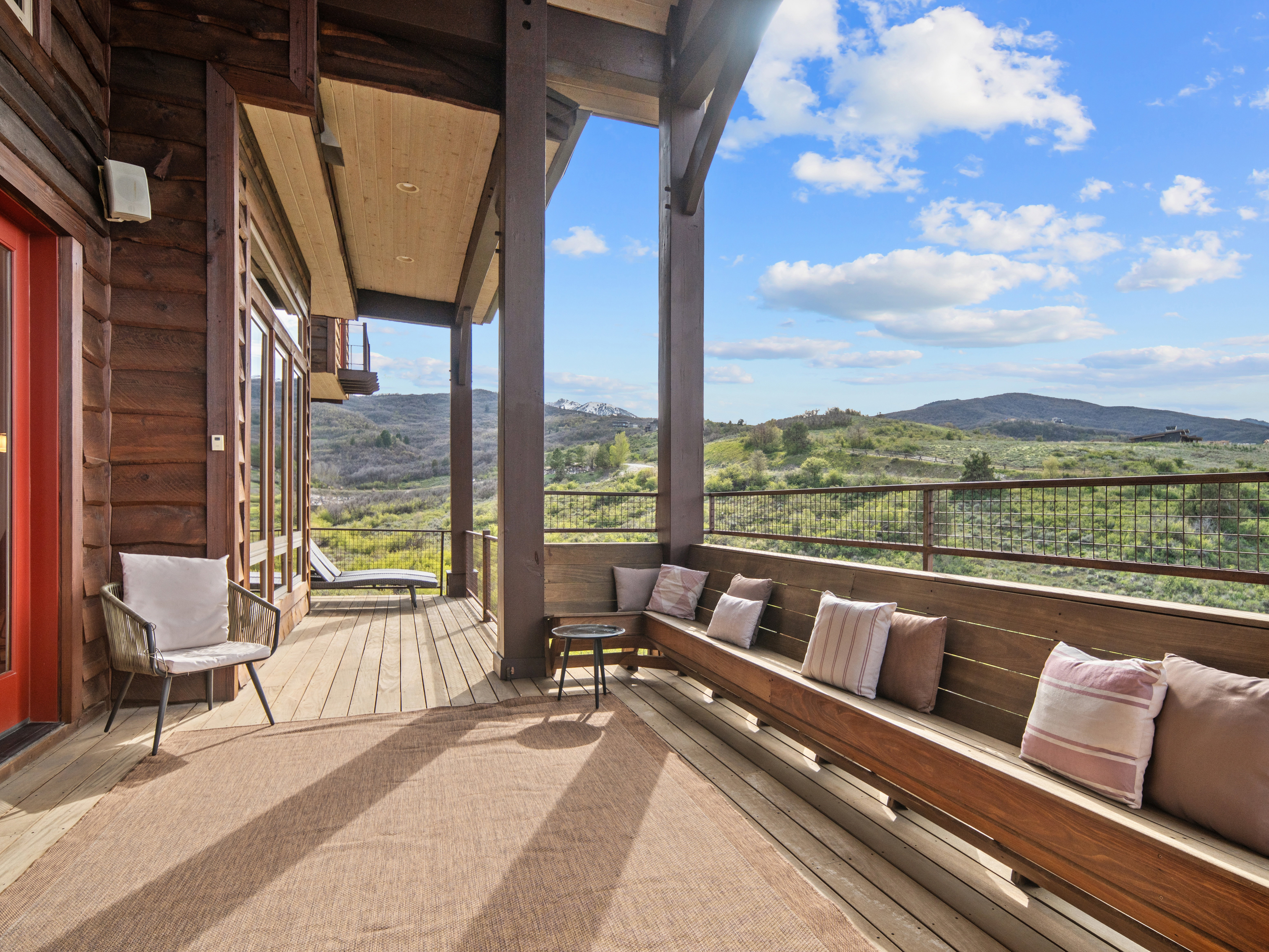 Expansive outdoor deck featuring wood-finish flooring and a built-in wooden bench