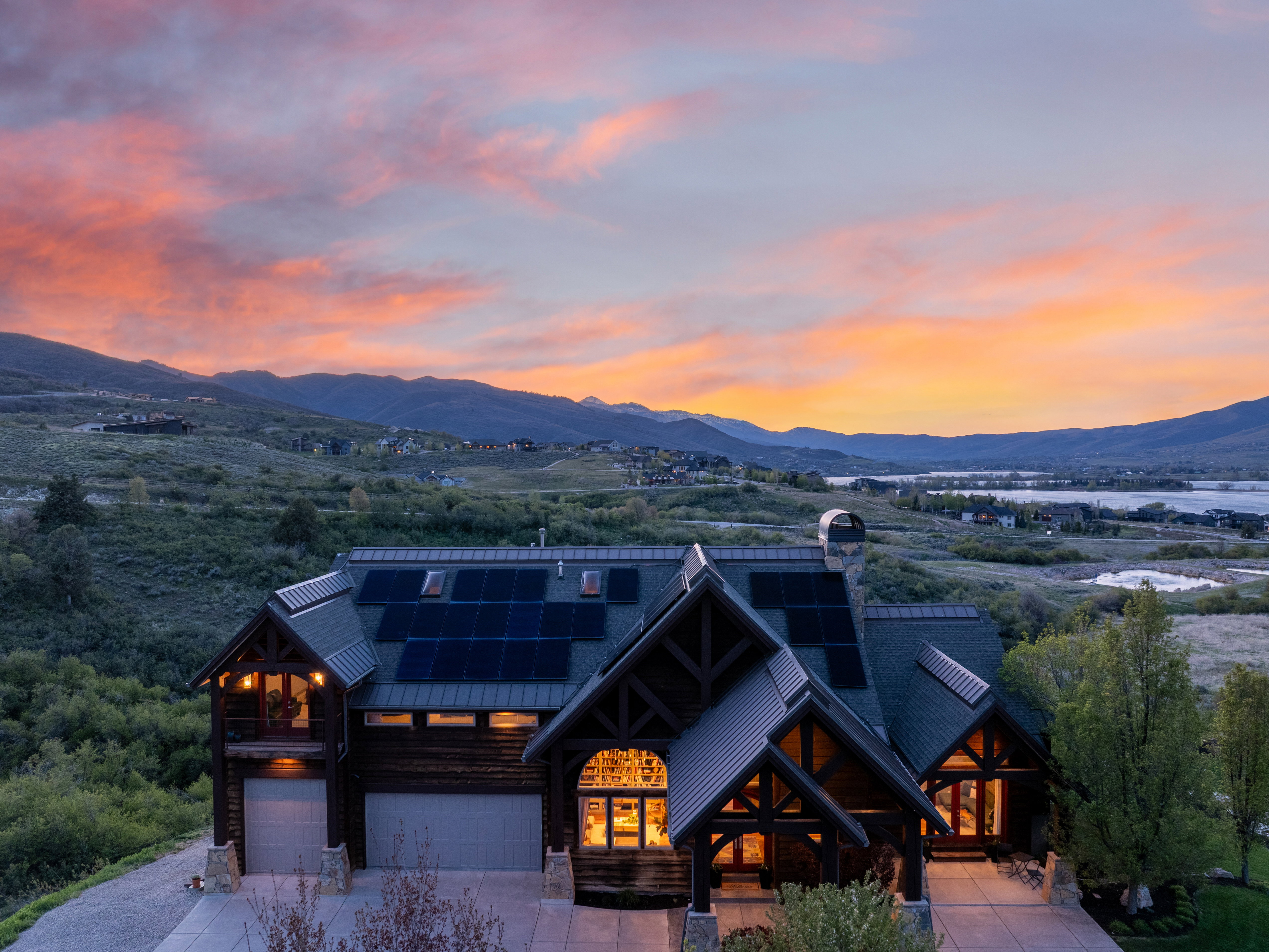 Mountain-style residence featuring a prominent gabled entrance, extensive wood siding, and multiple solar panels