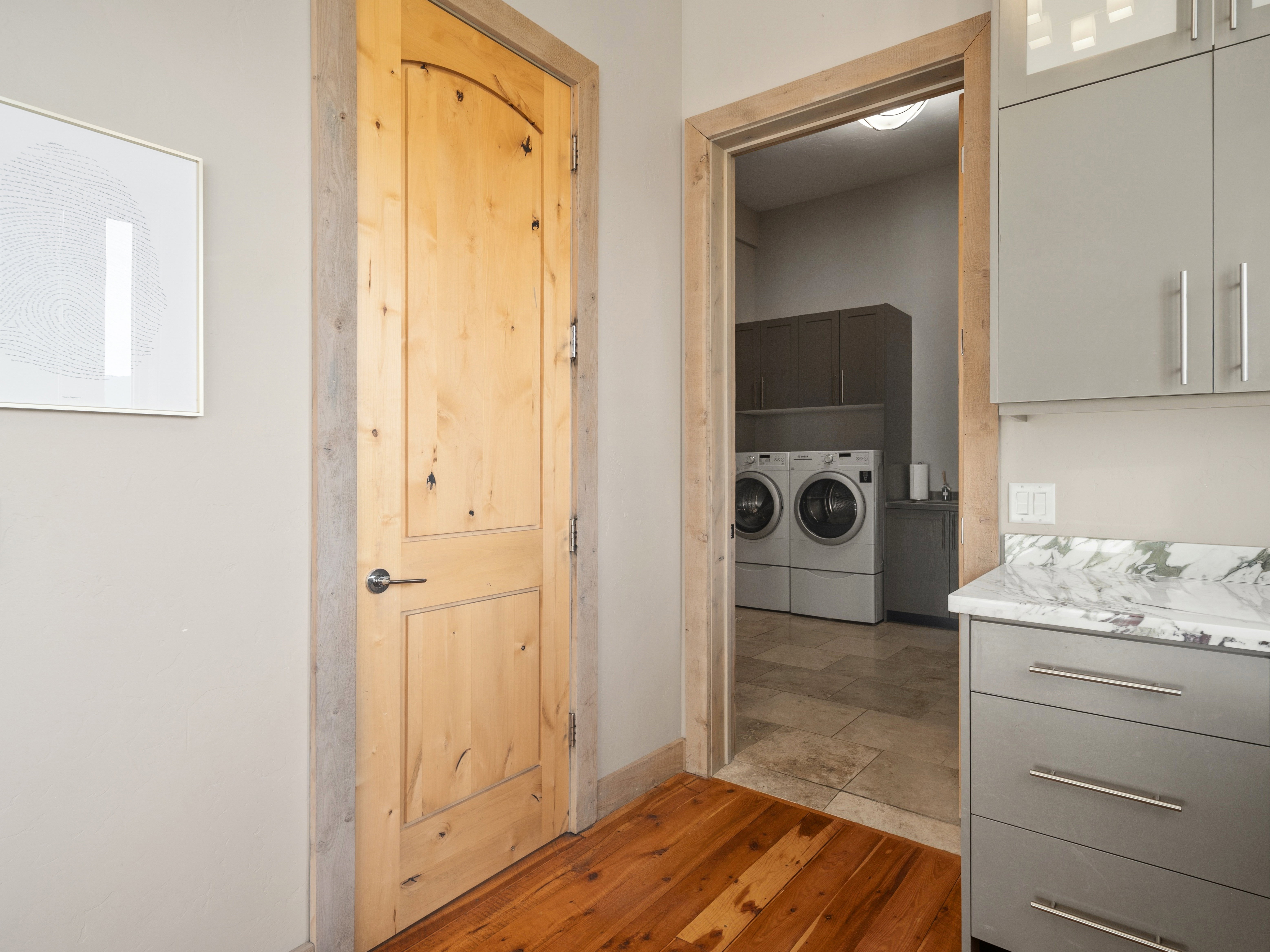 Laundry area featuring built-in cabinetry, dual front-load appliances, and tile flooring