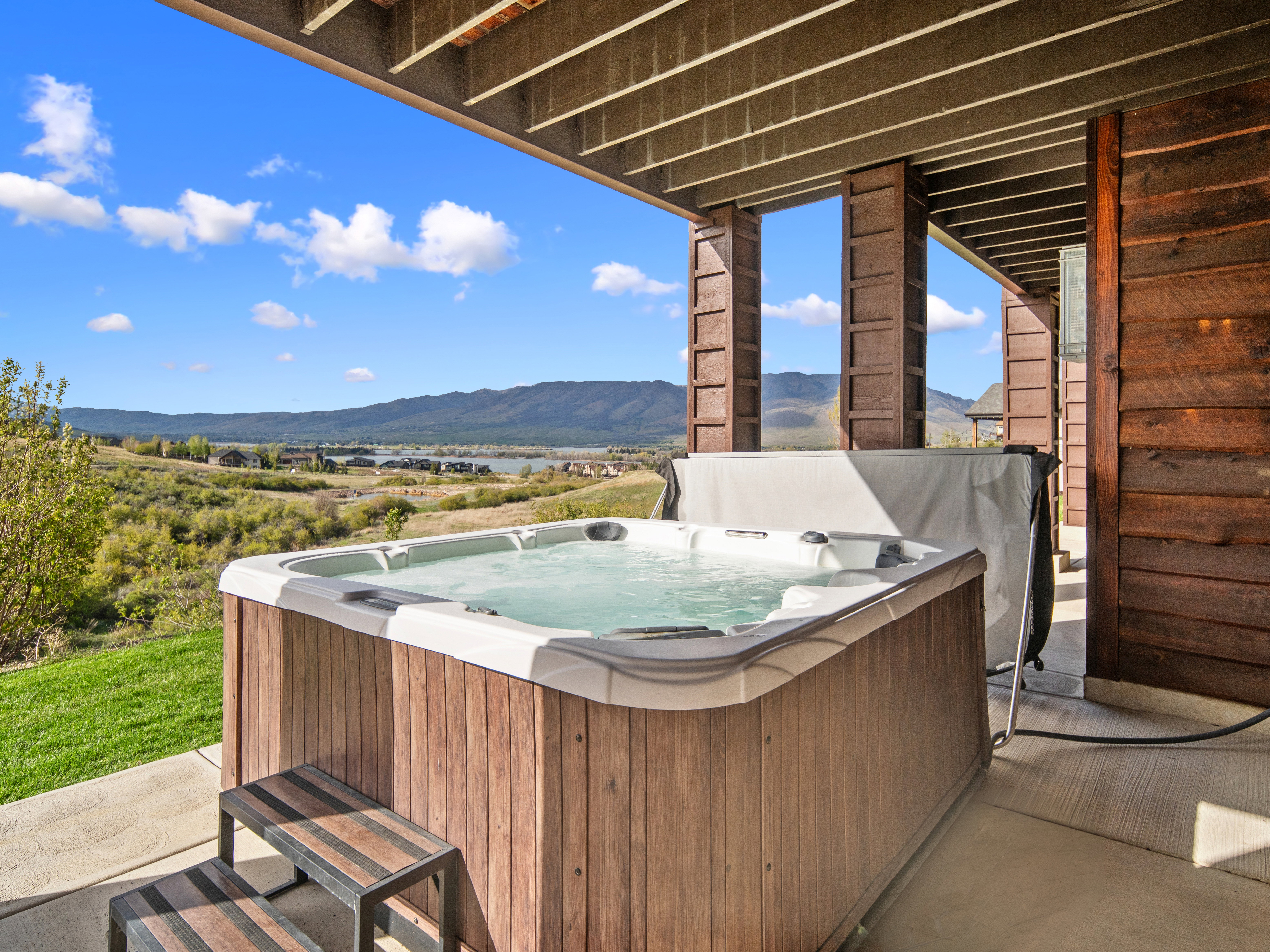 Outdoor hot tub featuring wood-finish siding and a protective cover