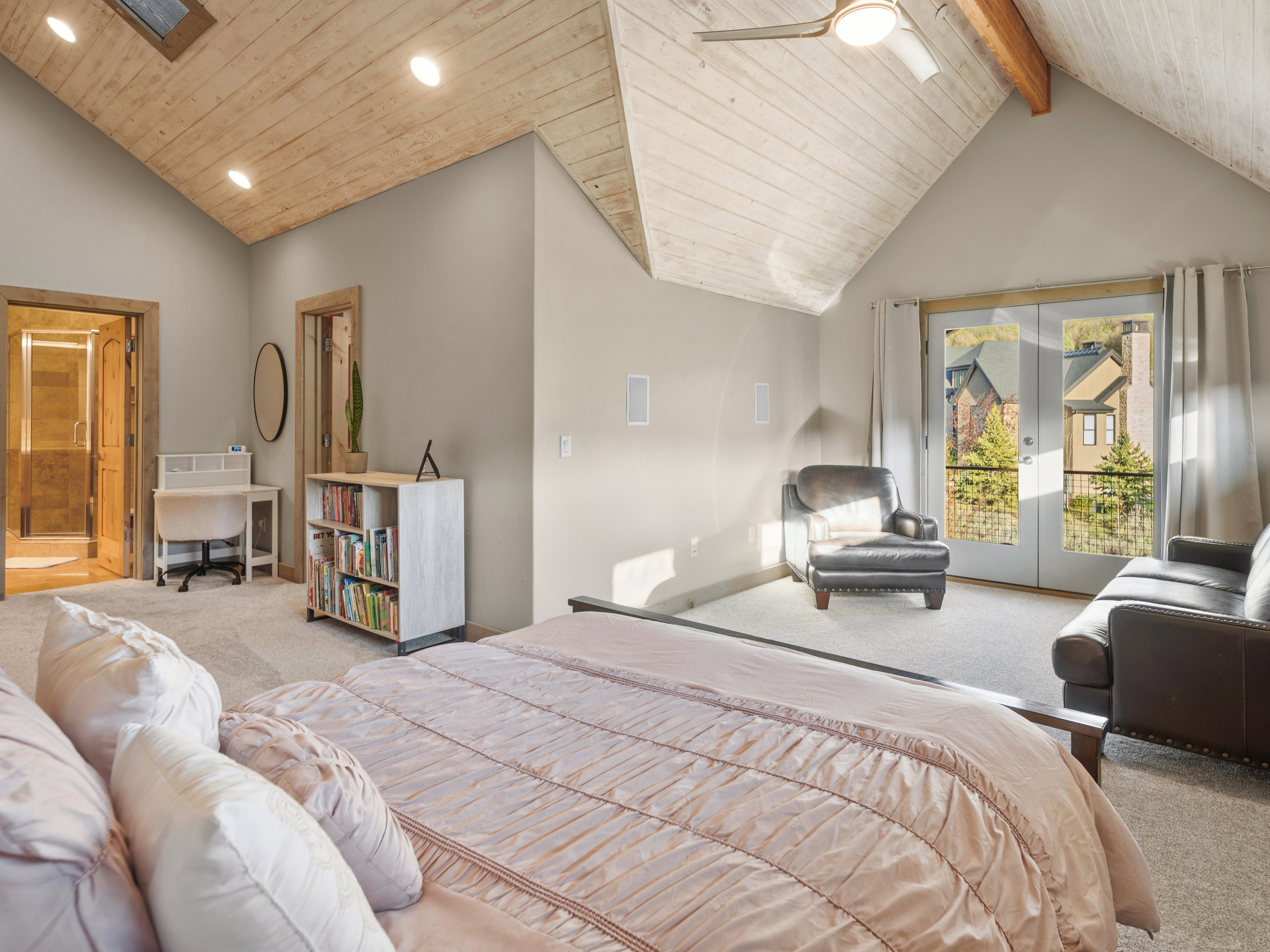 Vaulted wood-paneled ceilings with exposed wood beams, recessed lighting, and a ceiling fan