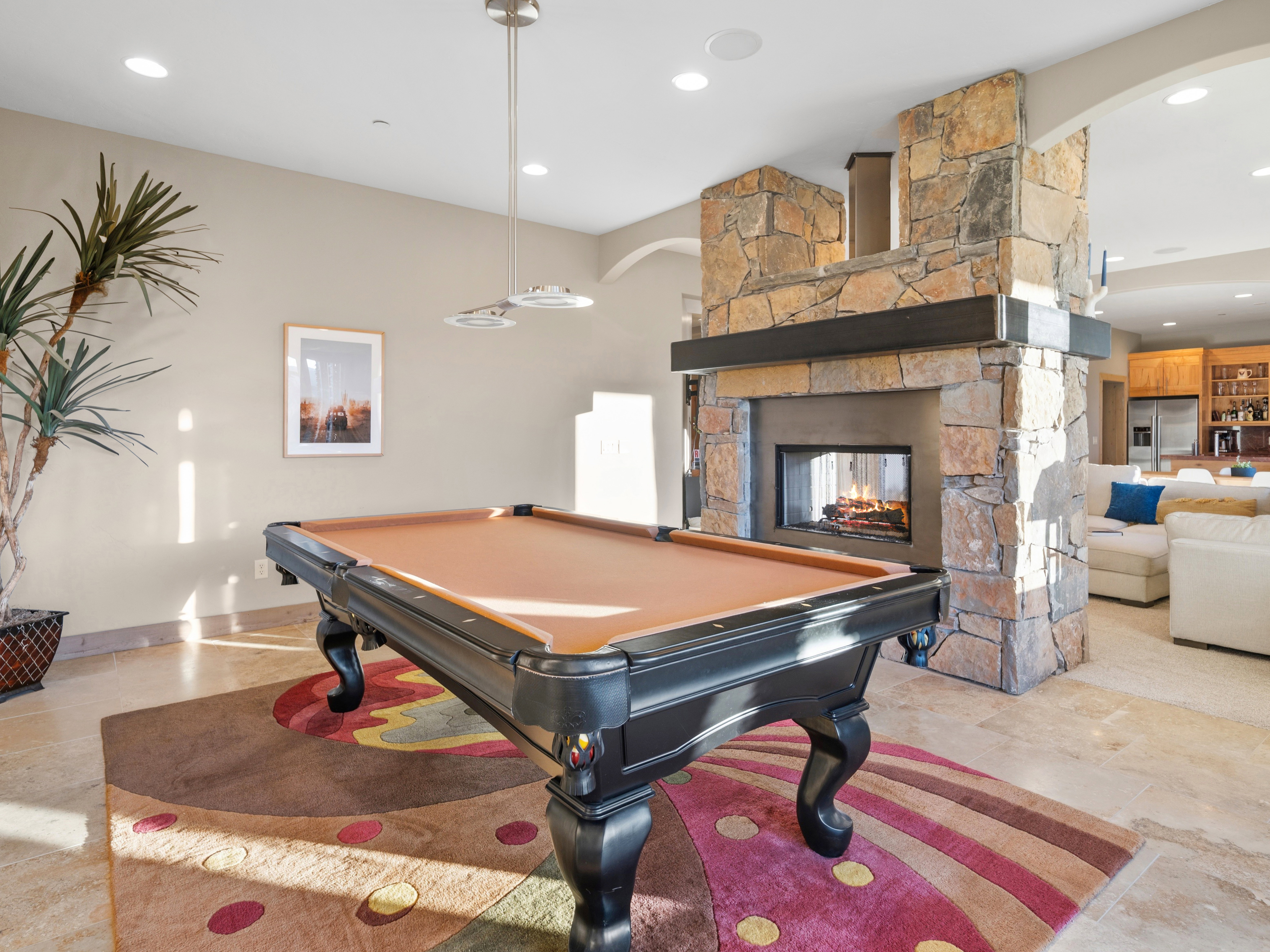 Stone-clad fireplace with a dark wood mantel and a multi-sided firebox