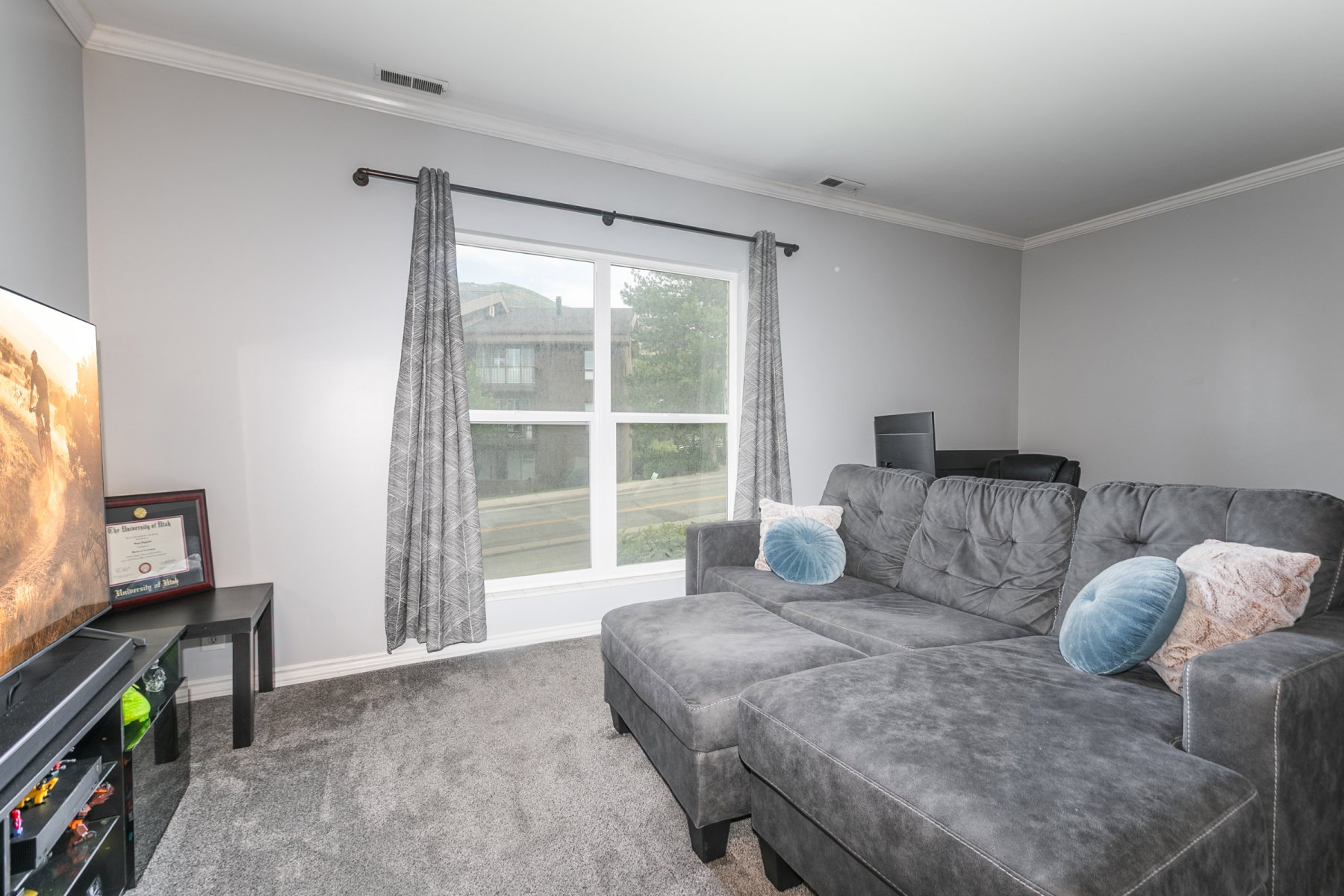 Living area with light gray wall paint and white crown molding