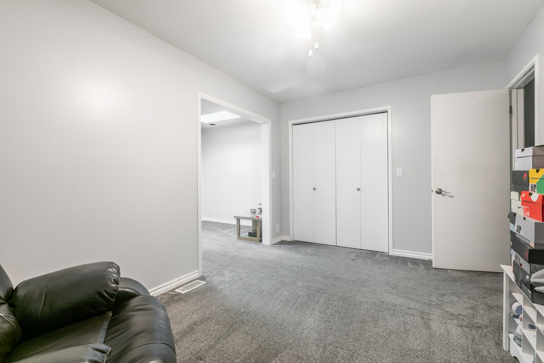 Carpeted room featuring a white bi-fold closet and a white interior door