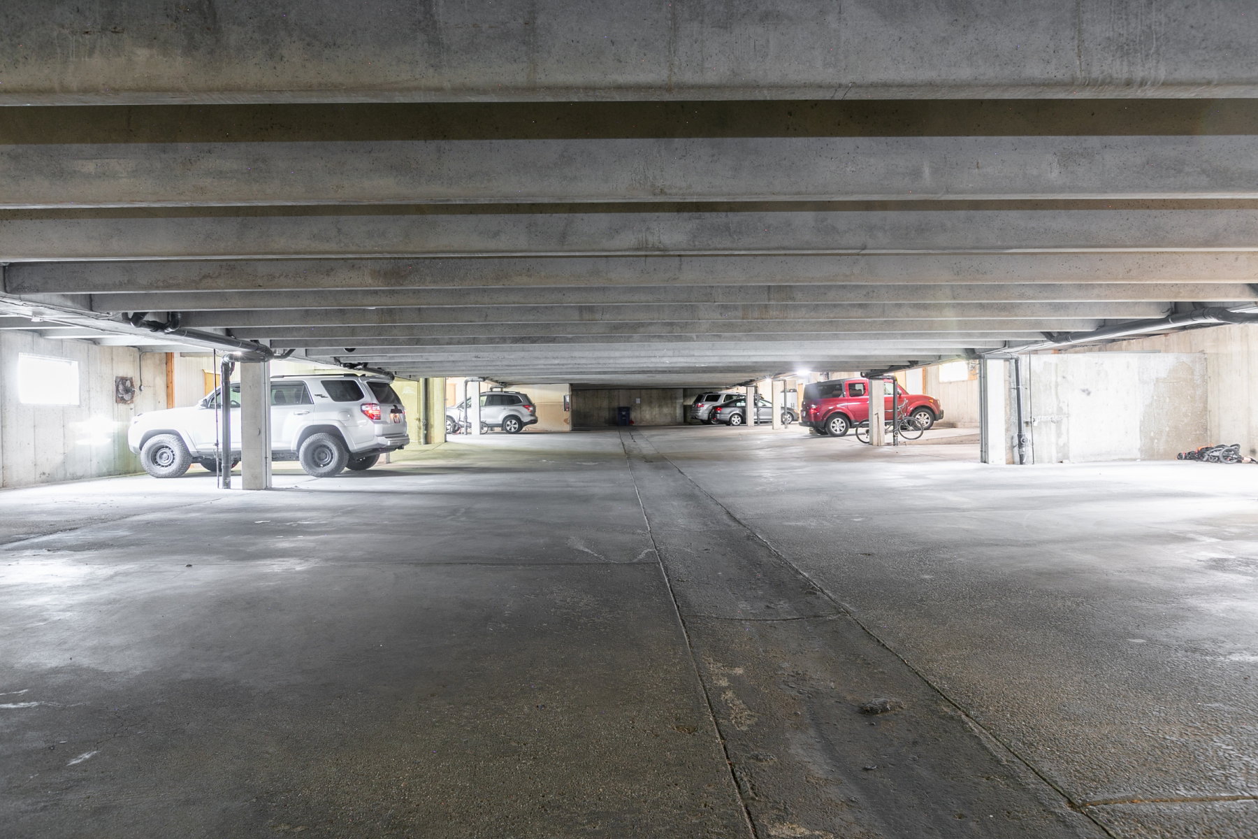 Underground parking garage featuring concrete flooring and structural beams