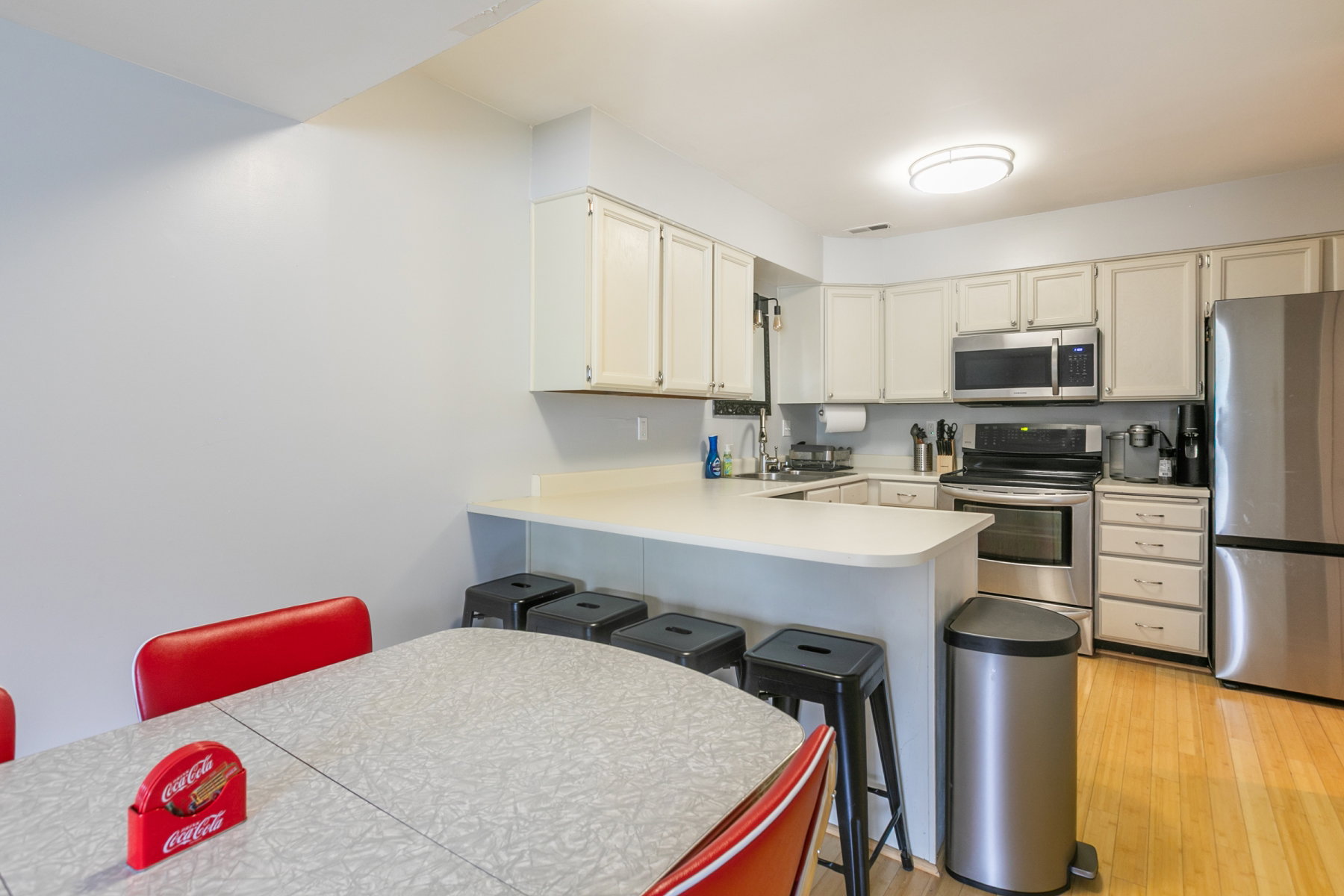 Kitchen featuring white cabinetry, light countertops, and stainless steel appliances