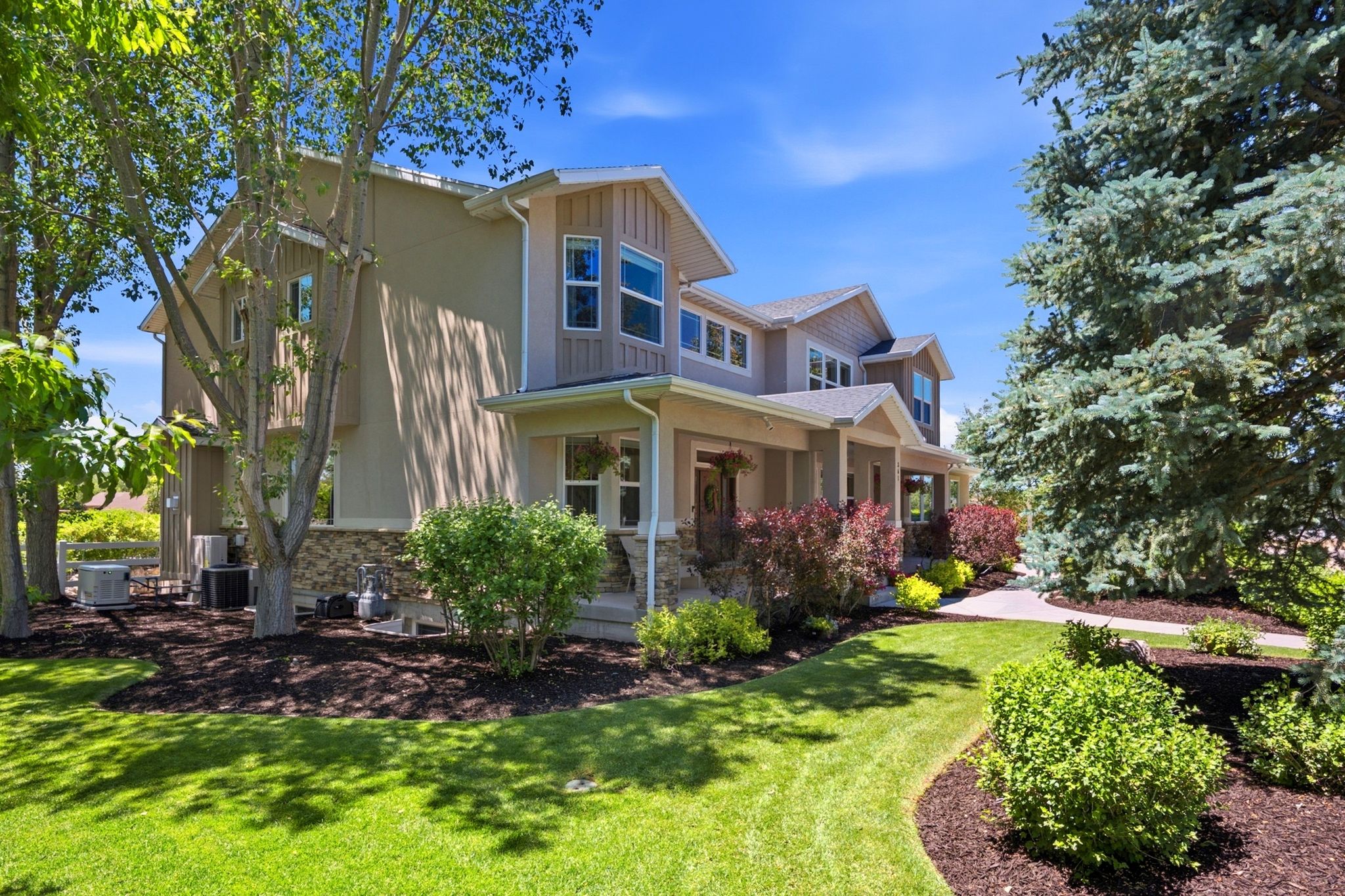 Multi-story residence featuring a combination of stucco and stone veneer siding