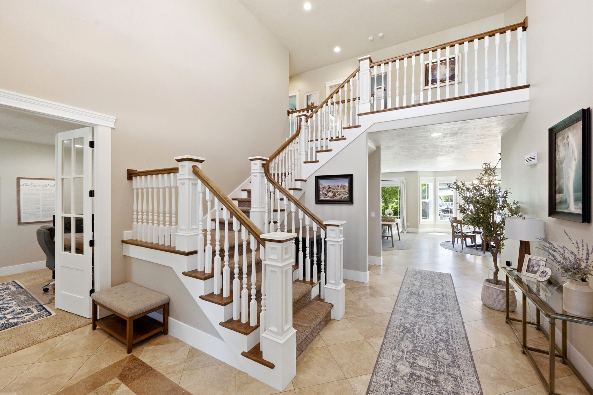 Grand staircase featuring wood treads, white risers, and turned balusters