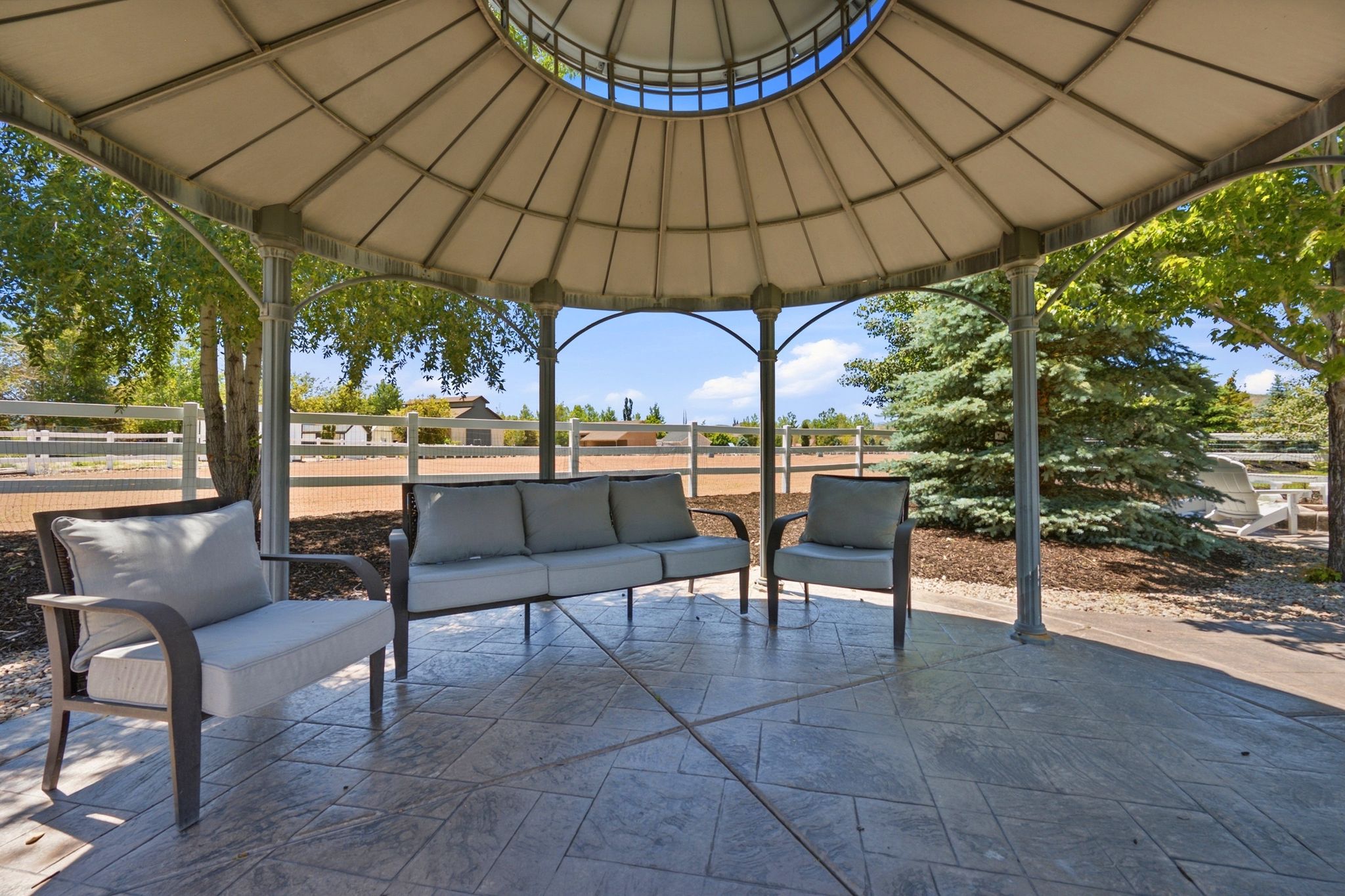 Outdoor gazebo featuring an ornate metal frame and a light-colored canopy
