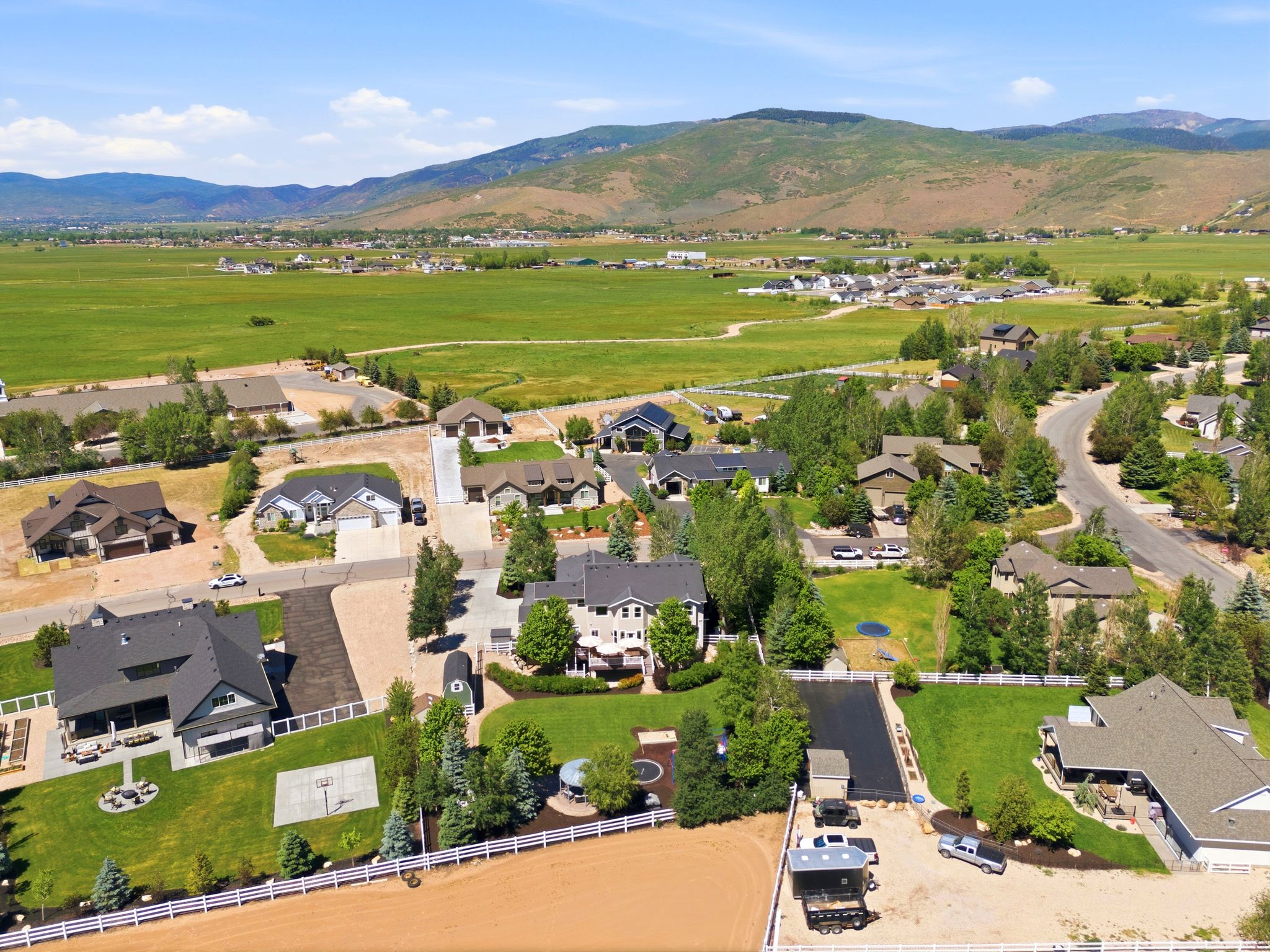 Expansive neighborhood with diverse residential architecture set against a mountainous, green landscape