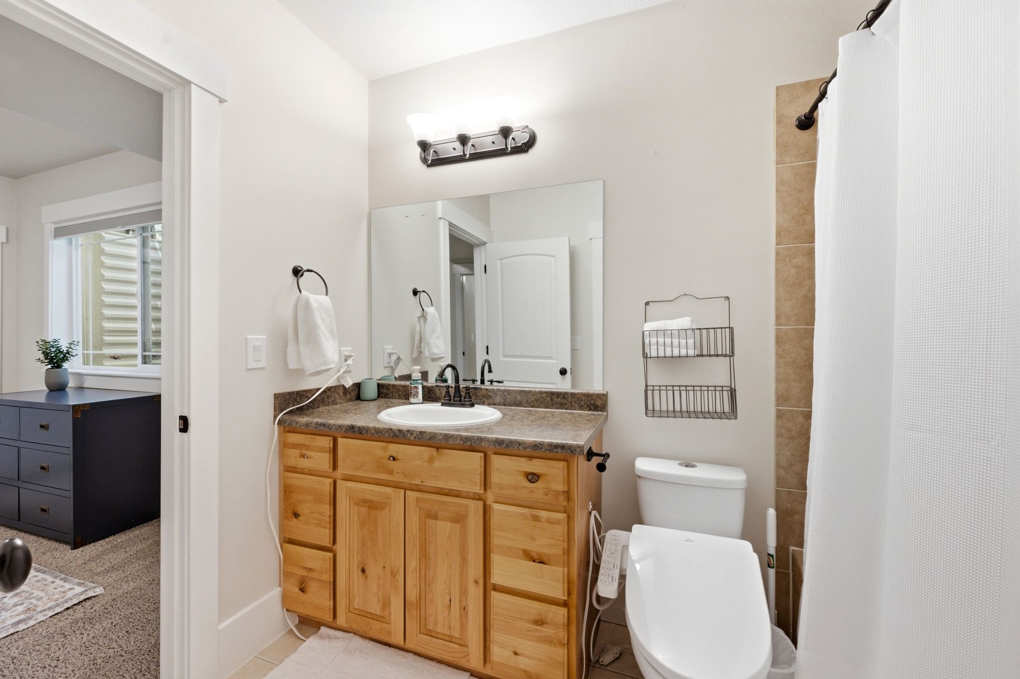 Bathroom vanity with wood-finish cabinetry and a speckled countertop