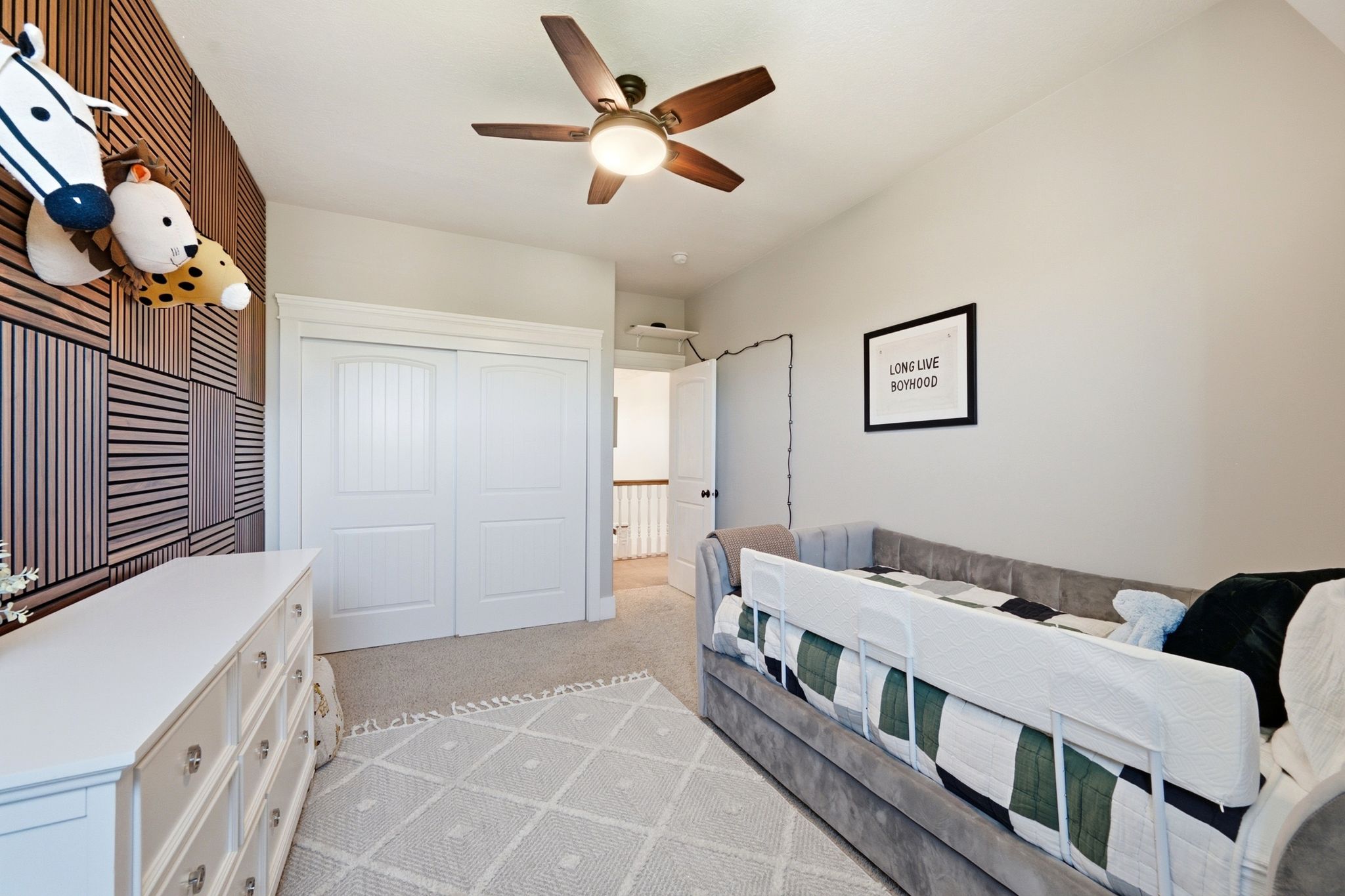 Interior room featuring a patterned accent wall, vaulted ceiling, and carpet flooring