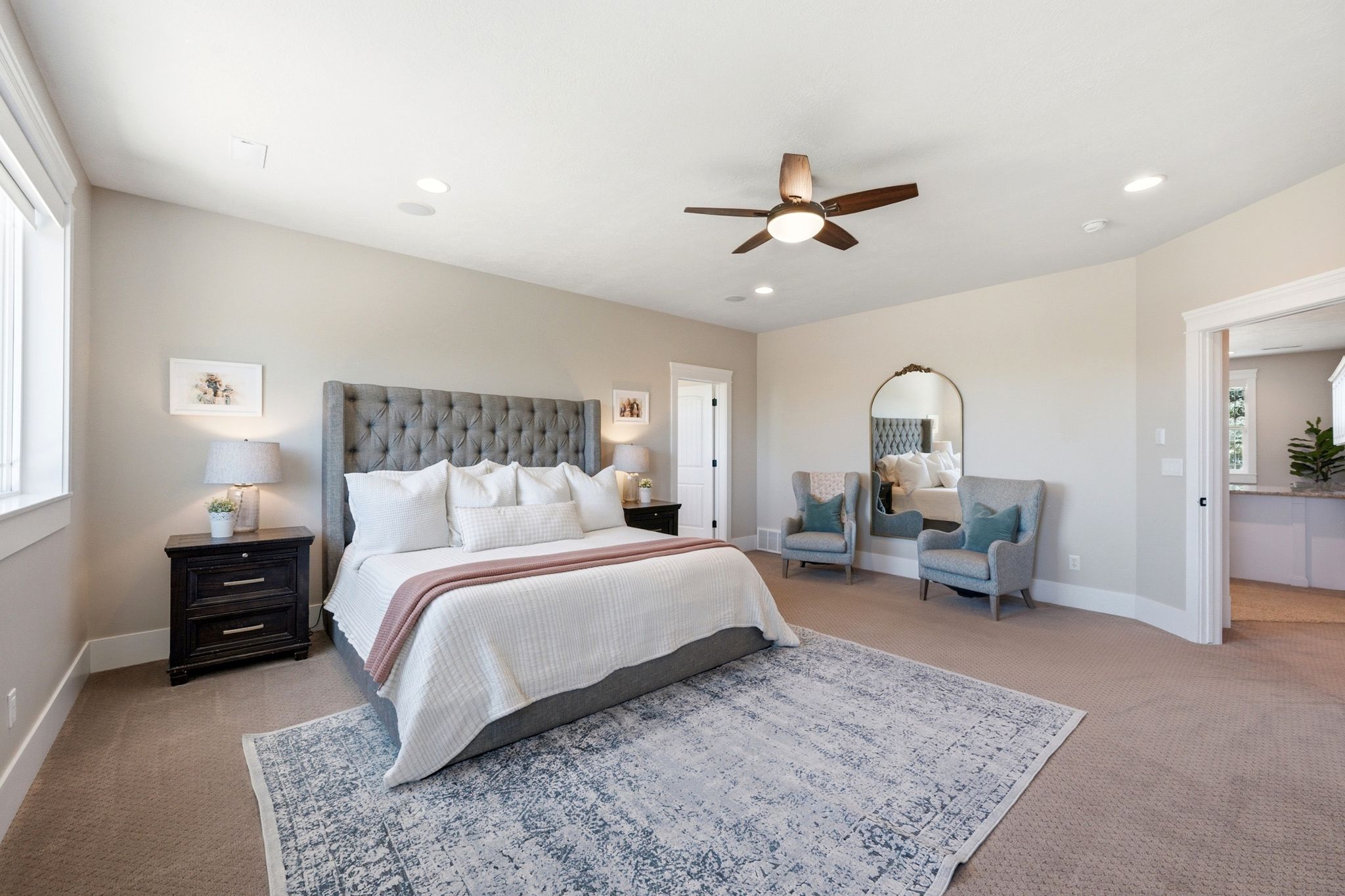 Spacious room featuring neutral carpeting, recessed lighting, a ceiling fan, and ample natural light from a large window