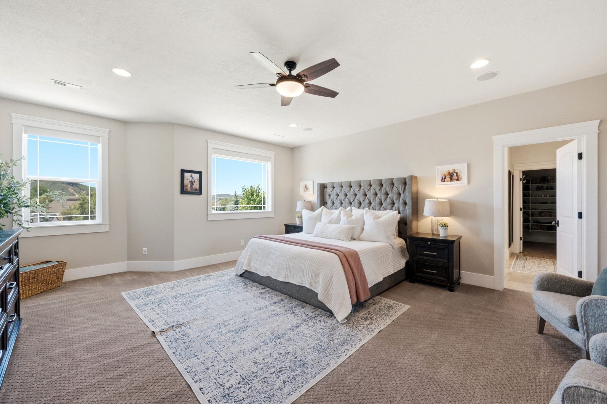 Spacious room featuring carpet flooring, recessed lighting, a ceiling fan, and multiple windows