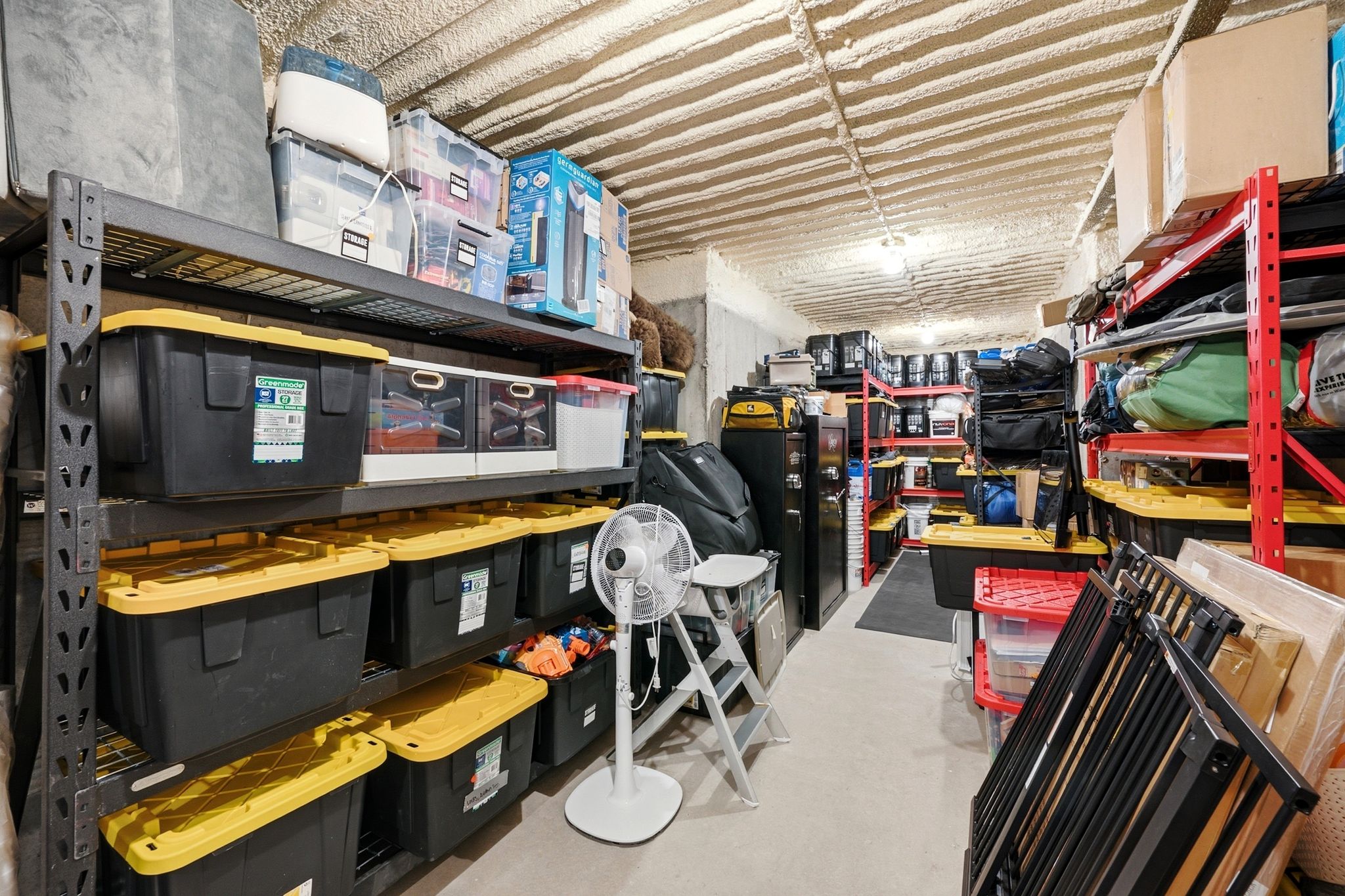 Spacious storage area featuring multiple heavy-duty shelving units, concrete flooring, and an insulated ceiling