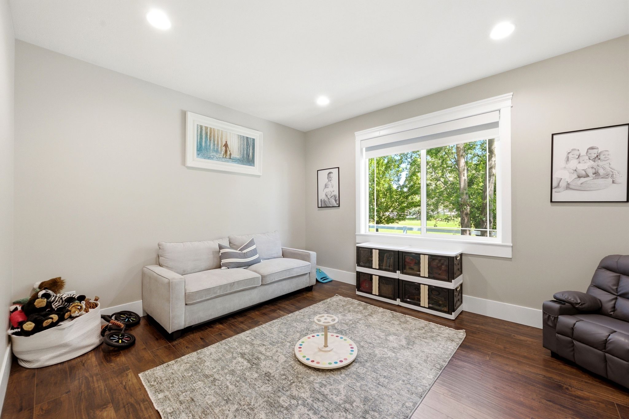 Spacious room featuring wood-finish flooring, recessed lighting, and a large window with white trim