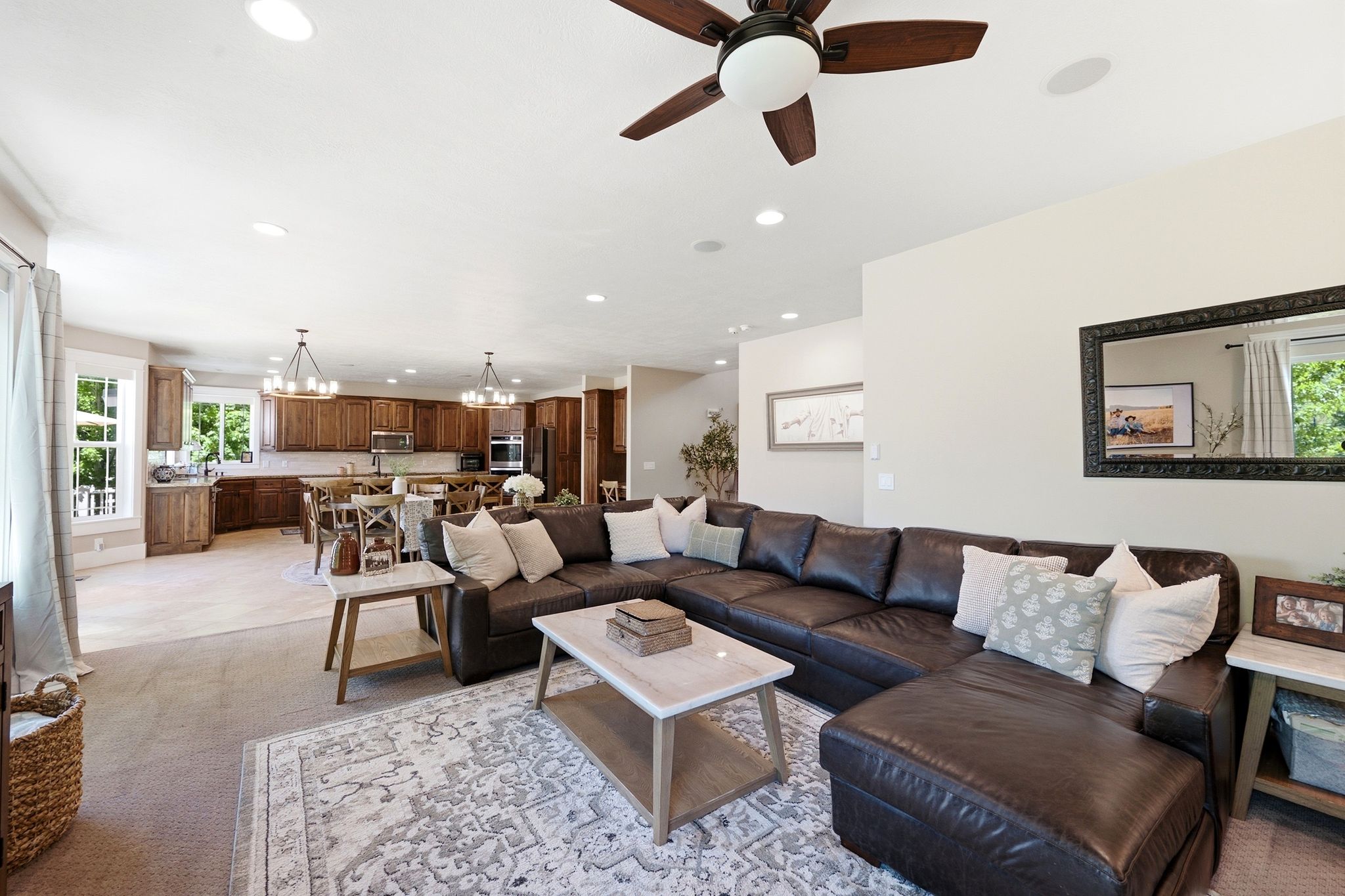 Open-concept living area with a ceiling fan, recessed lighting, and a neutral color palette