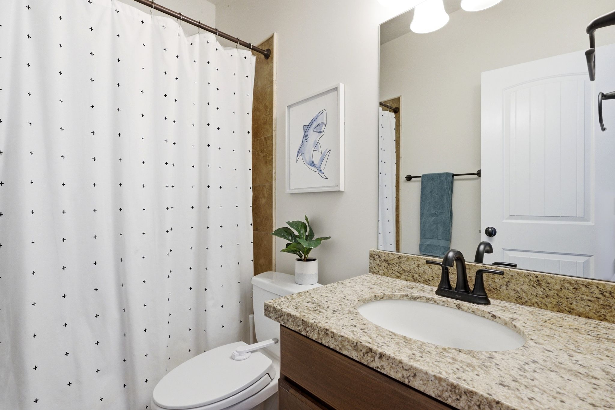 Bathroom vanity with granite countertop, undermount sink, and dark bronze-finish fixtures