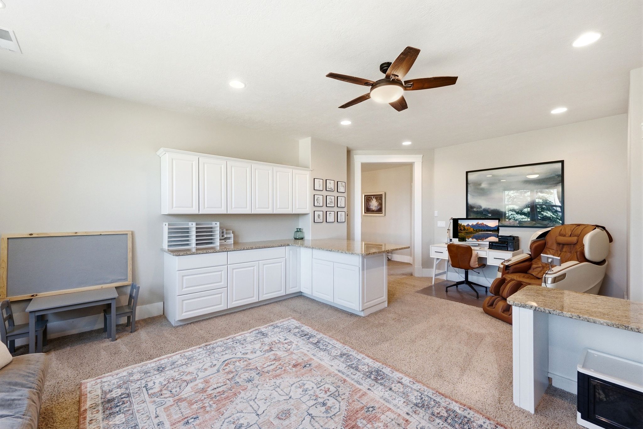 Open-concept room featuring extensive built-in white cabinetry with a light-colored countertop