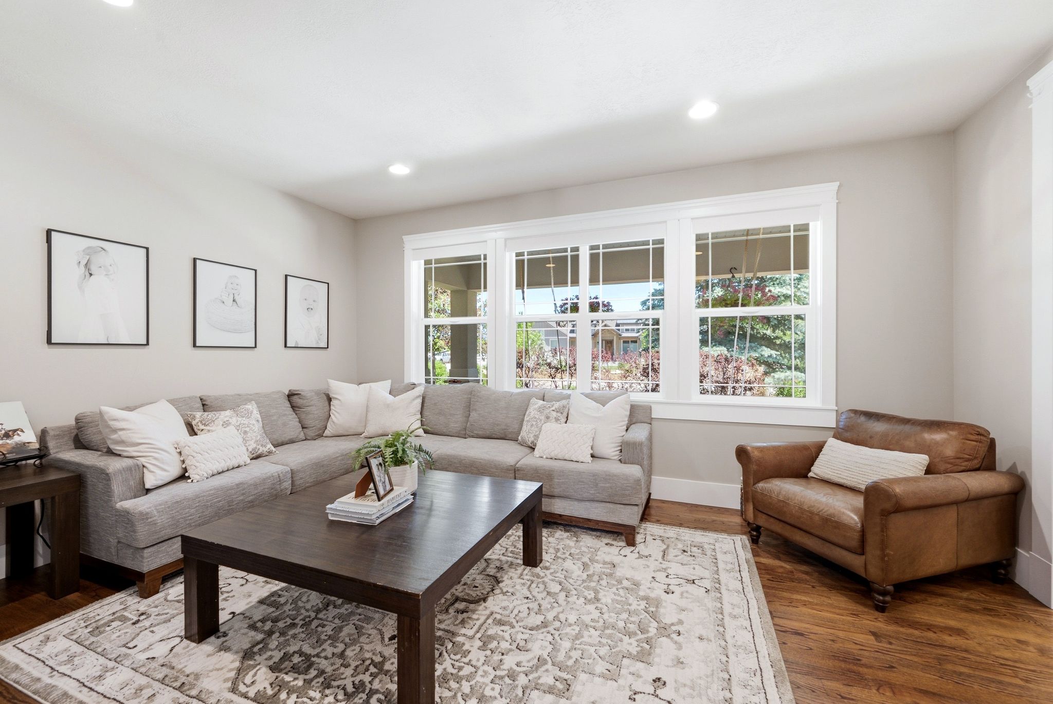 Living area featuring wood-finish flooring, recessed lighting, and a large window with white trim
