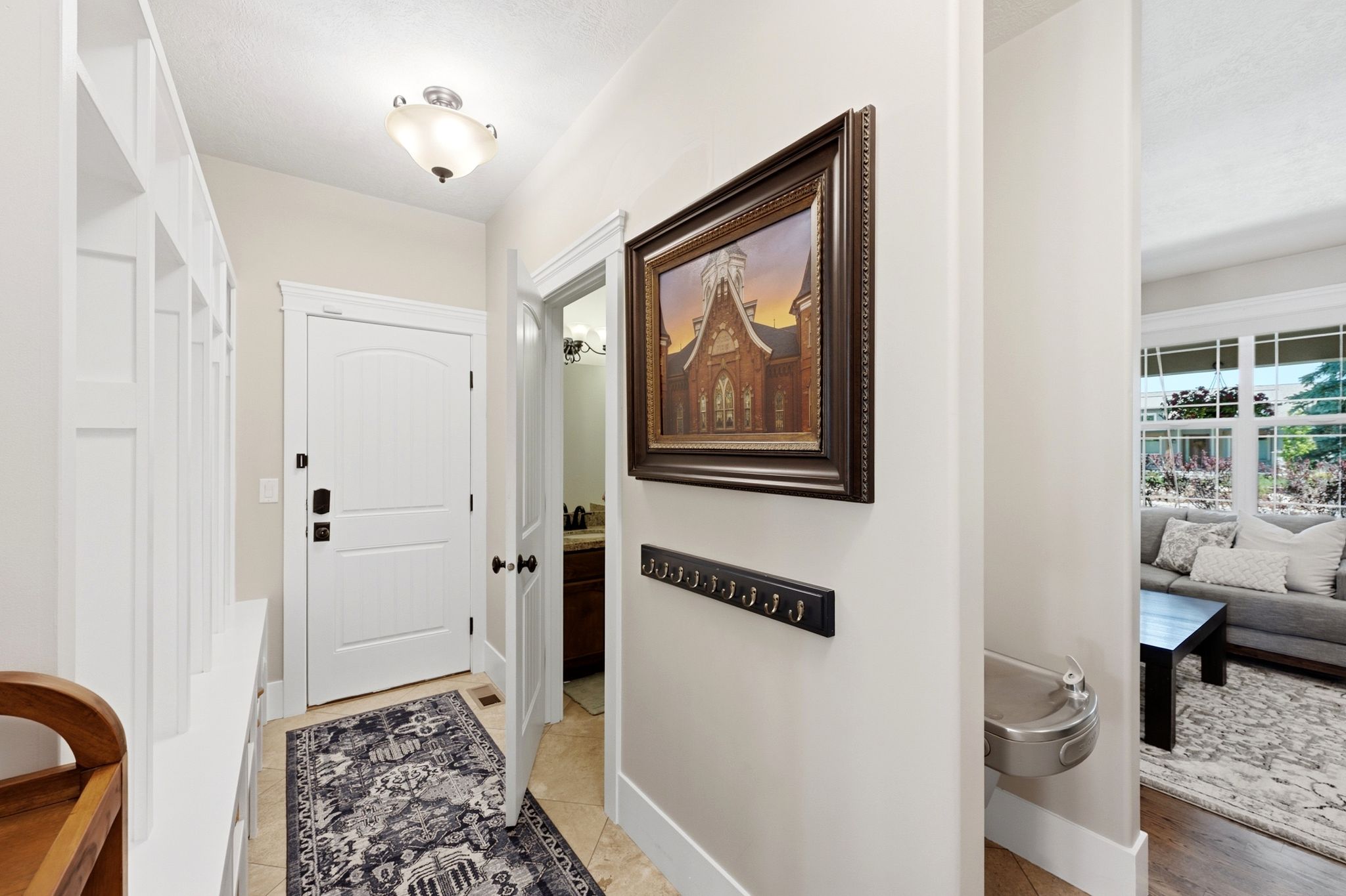 Entryway with built-in storage cubbies, arched panel interior door, and tile flooring