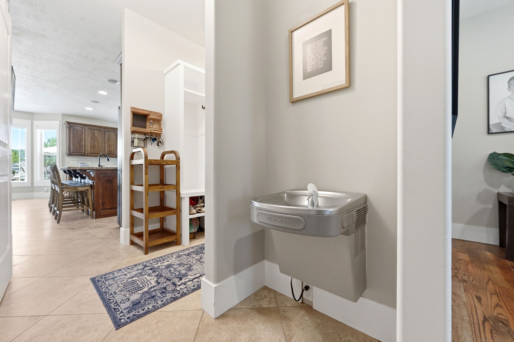 Integrated drinking fountain with a light-toned wall finish