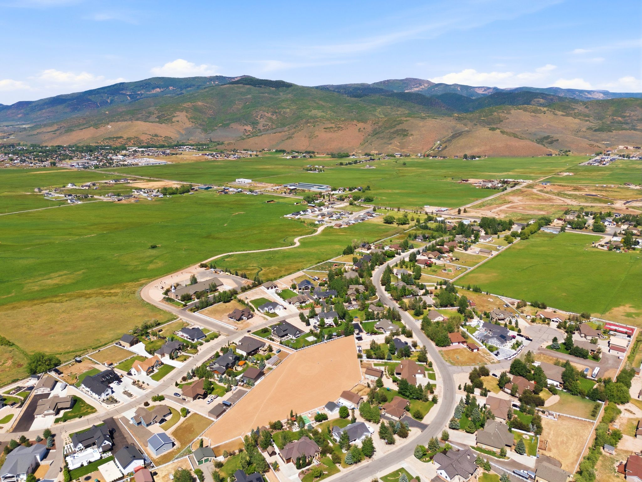 Aerial perspective showcasing a residential development with established homes and vacant lots