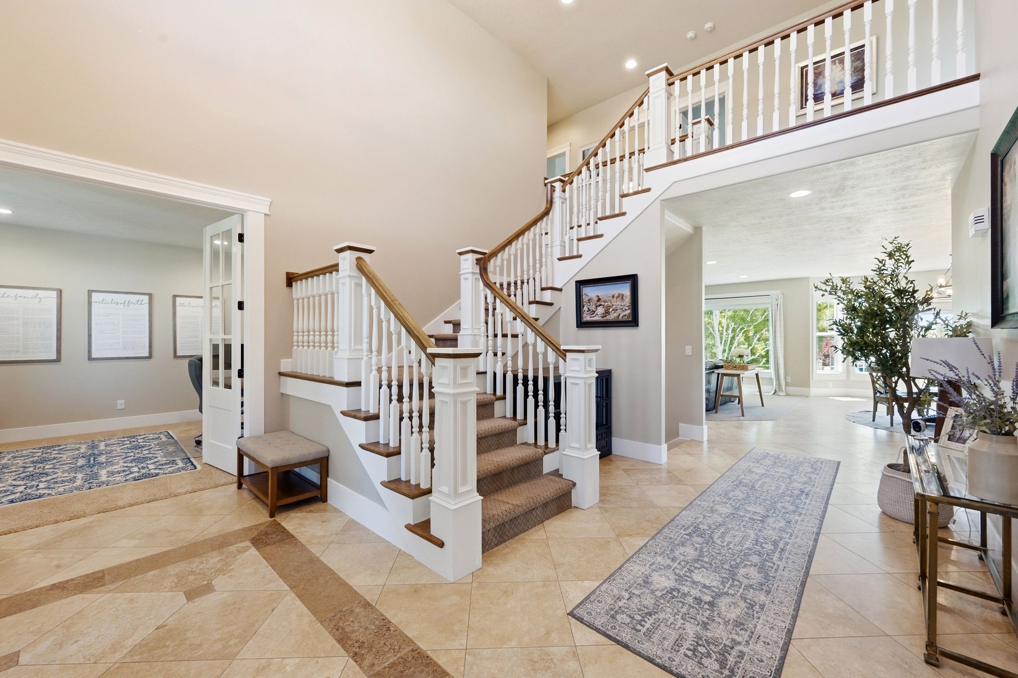 Two-story entry featuring a curved staircase with white balusters and wood handrails