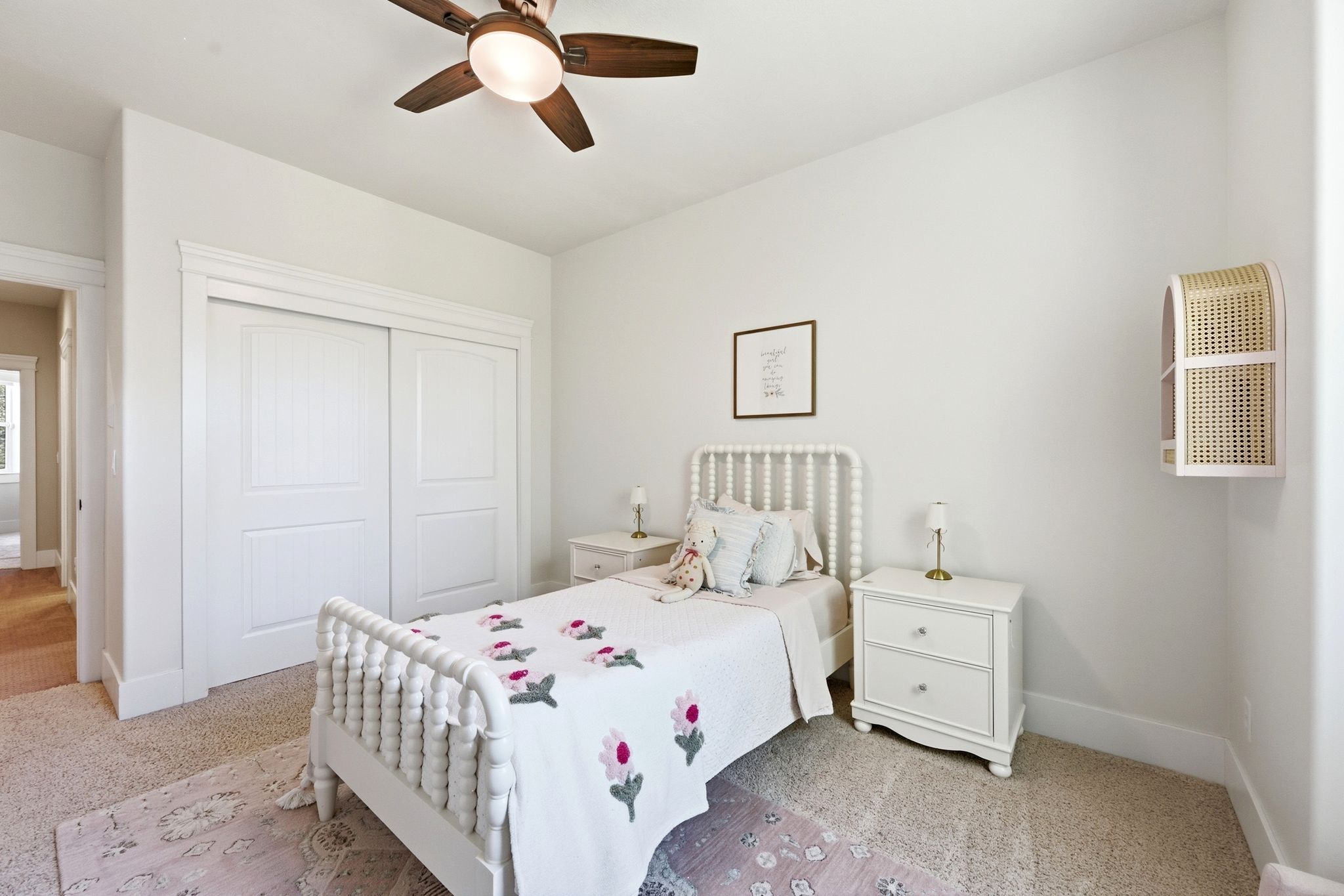Bedroom featuring a ceiling fan with integrated lighting, textured carpeting, and a built-in closet with sliding panel doors