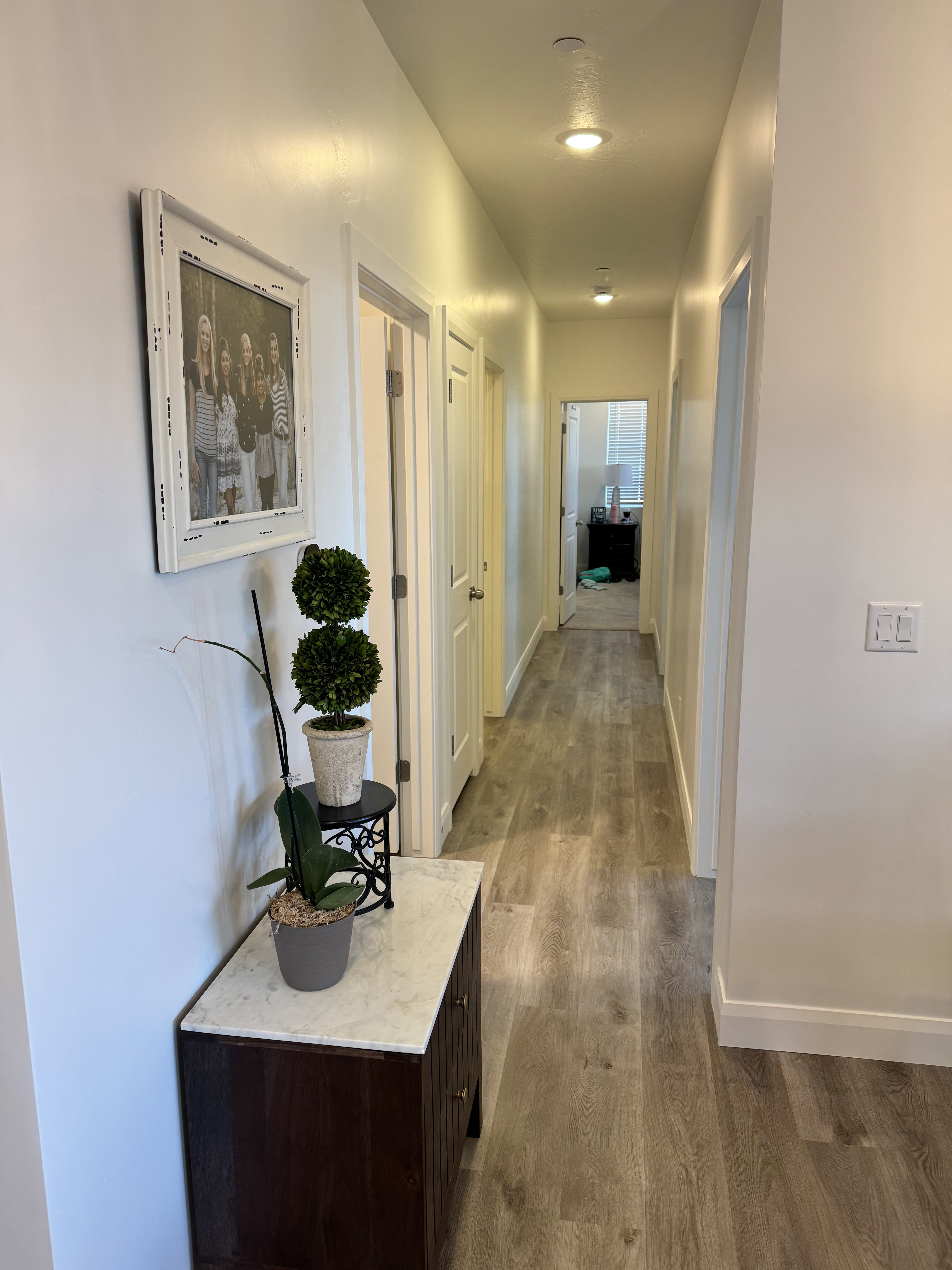 Hallway featuring wood-finish flooring, recessed lighting, white walls, and white trim