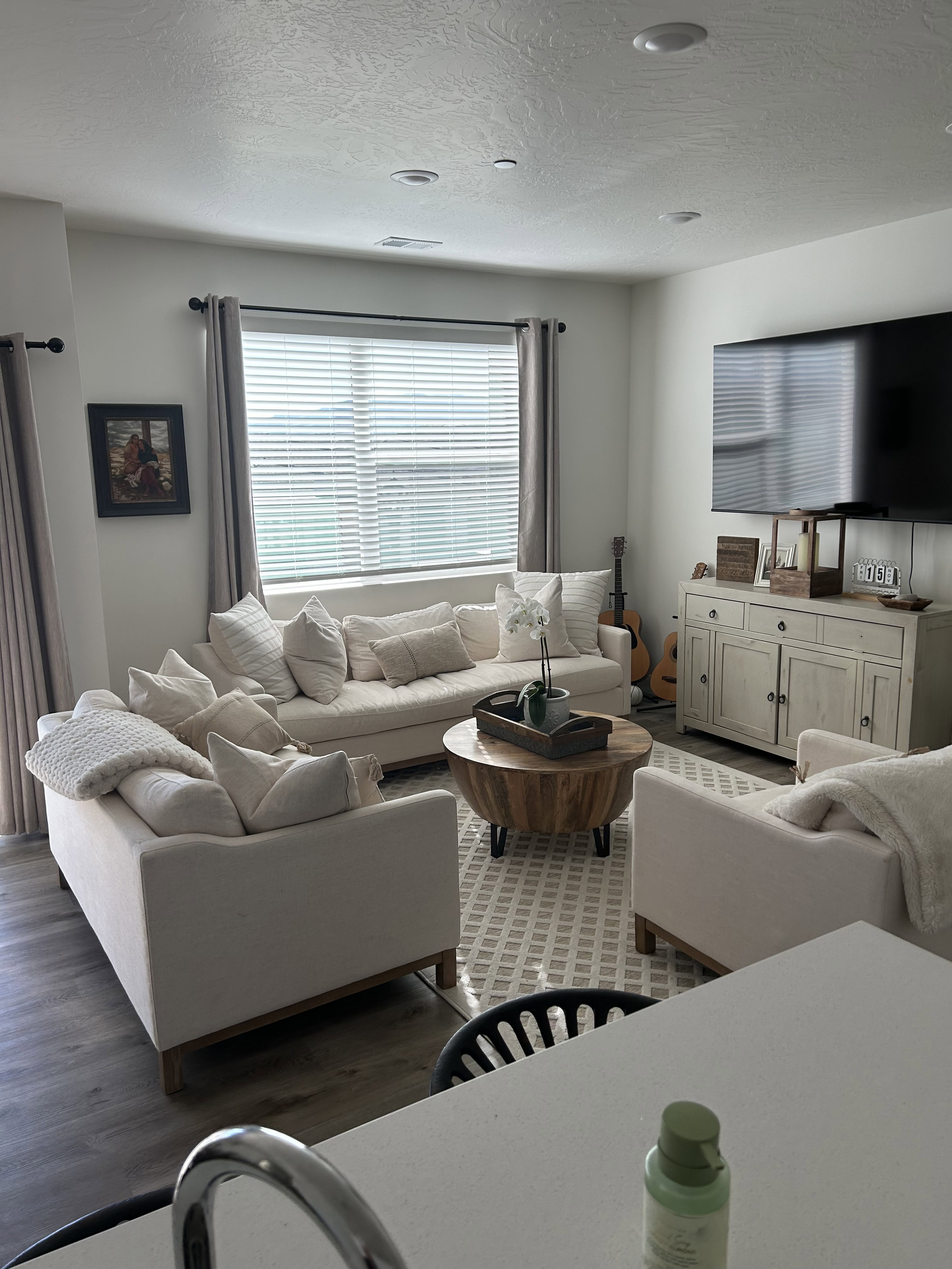Living area featuring wood-finish flooring, recessed lighting, and a large window with blinds