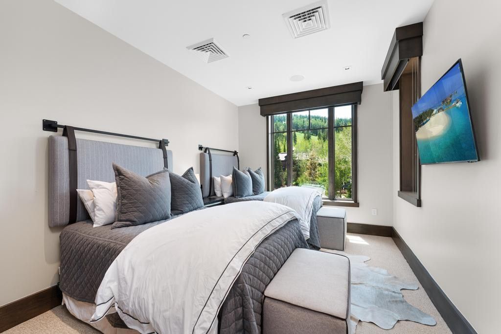 Dual beds with upholstered headboards and integrated wall-mounted lighting