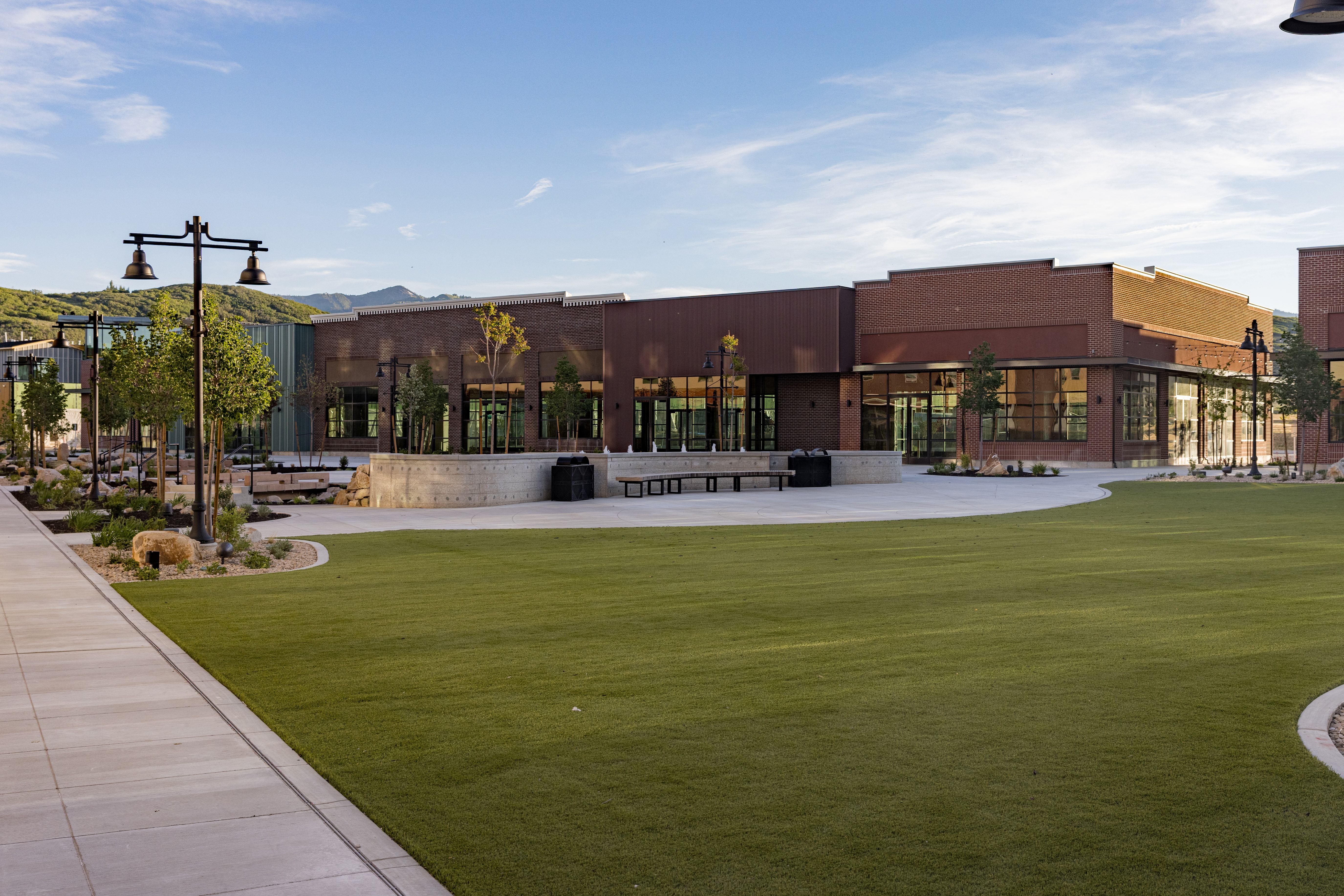 Expansive green lawn with surrounding concrete pathways and contemporary street lighting