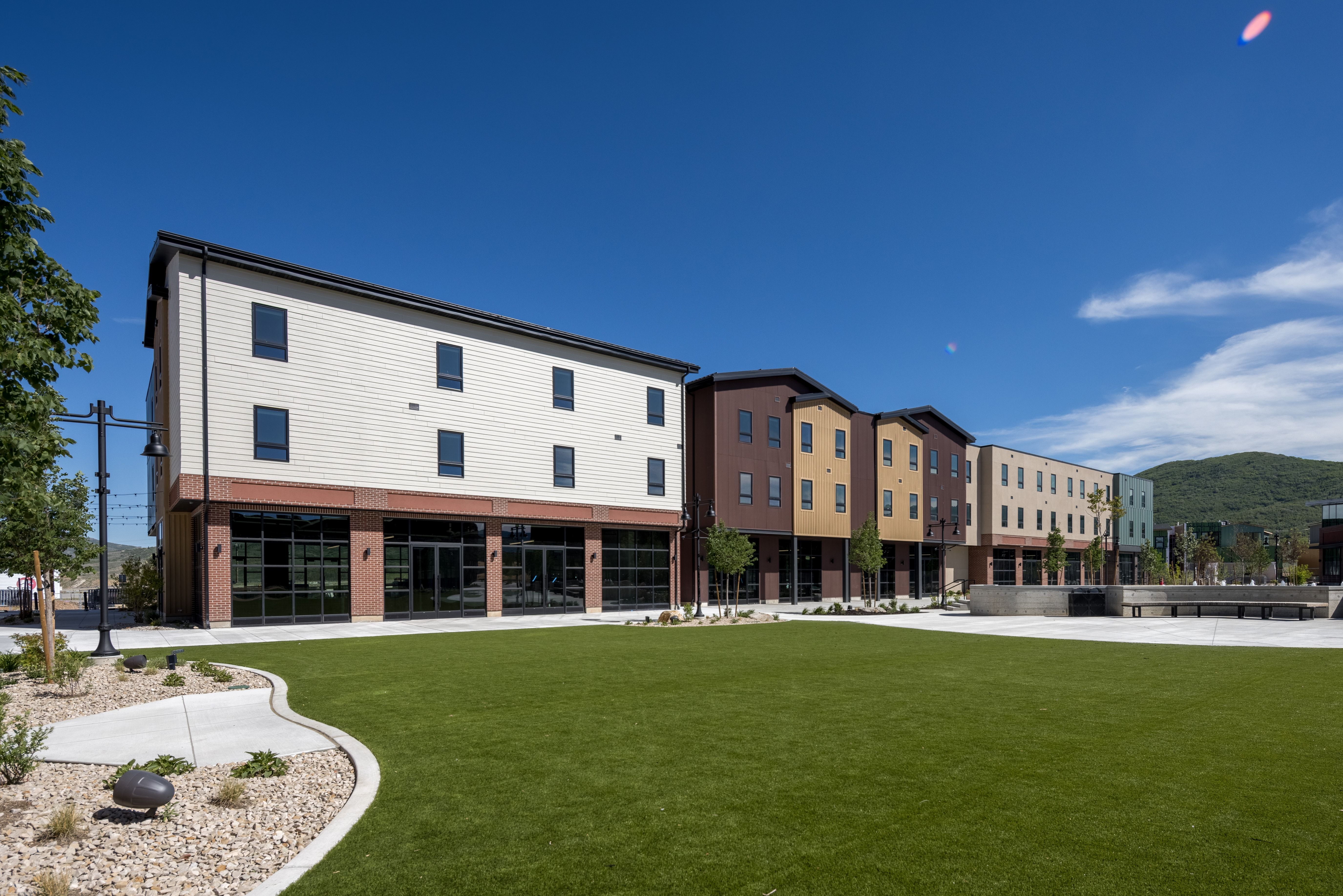 Expansive green space featuring a manicured lawn, surrounding concrete pathways, and integrated landscaping