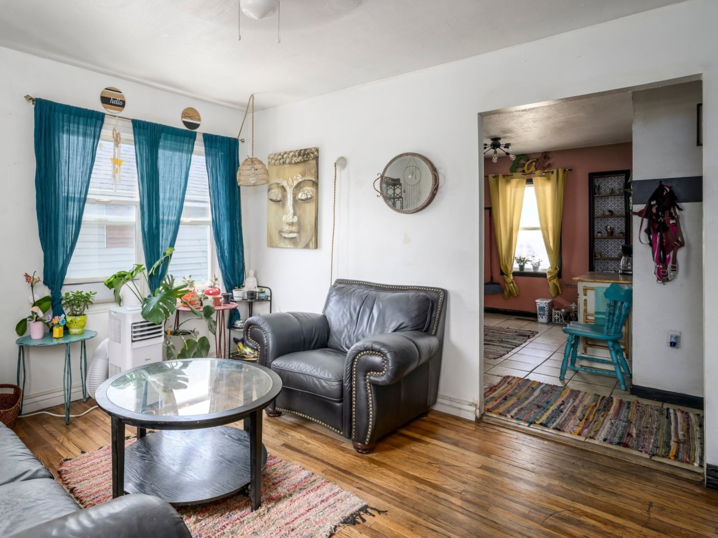 Living area featuring wood-finish flooring, white walls, and a ceiling fan with light fixture
