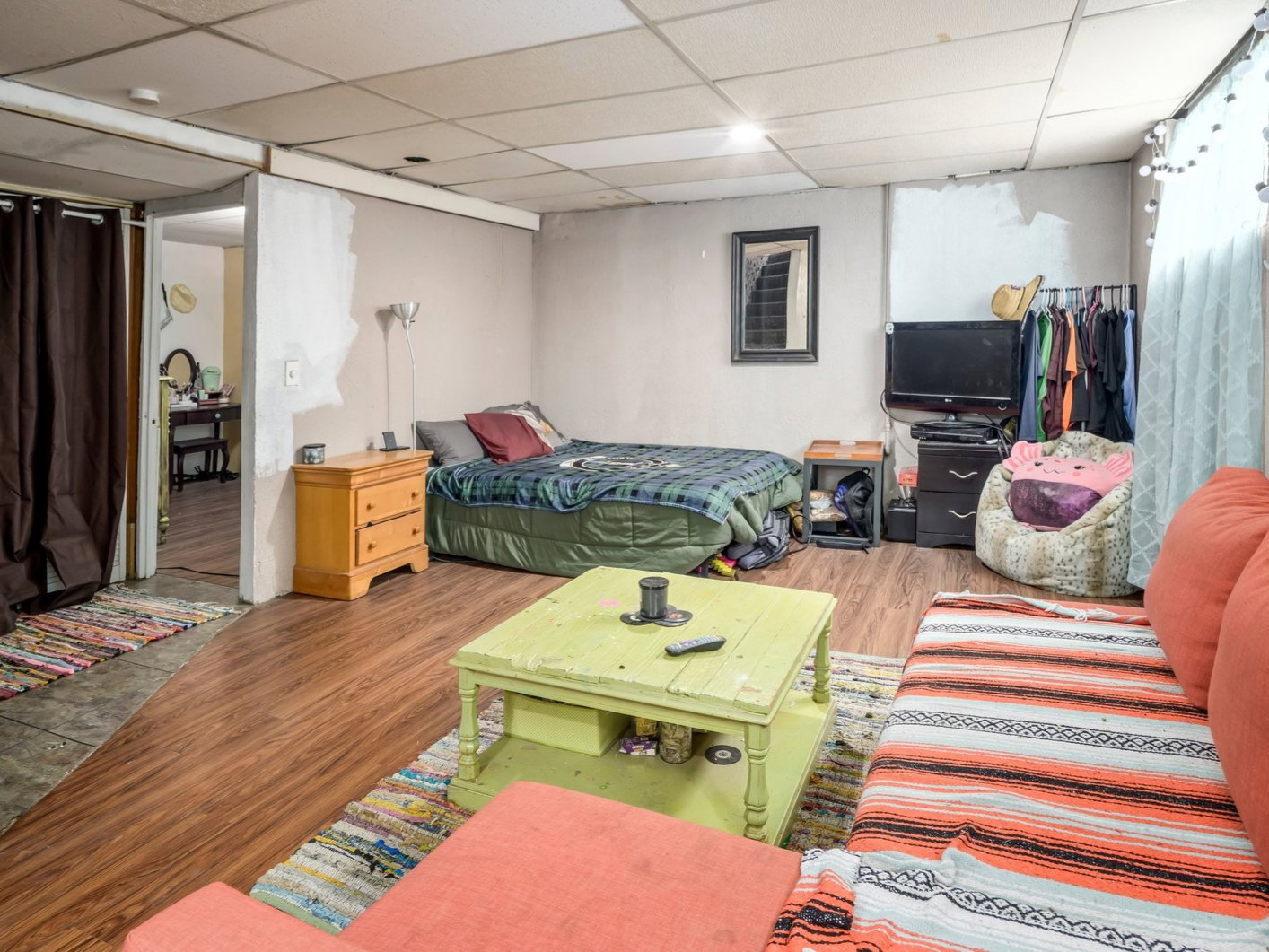 Versatile lower level space featuring wood-finish flooring, a drop ceiling, and distinct areas for various uses