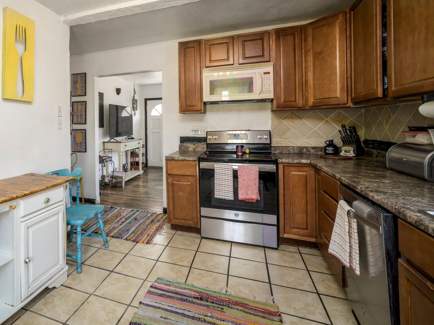 Kitchen featuring wood-finish cabinetry, stainless steel appliances, and a tile backsplash