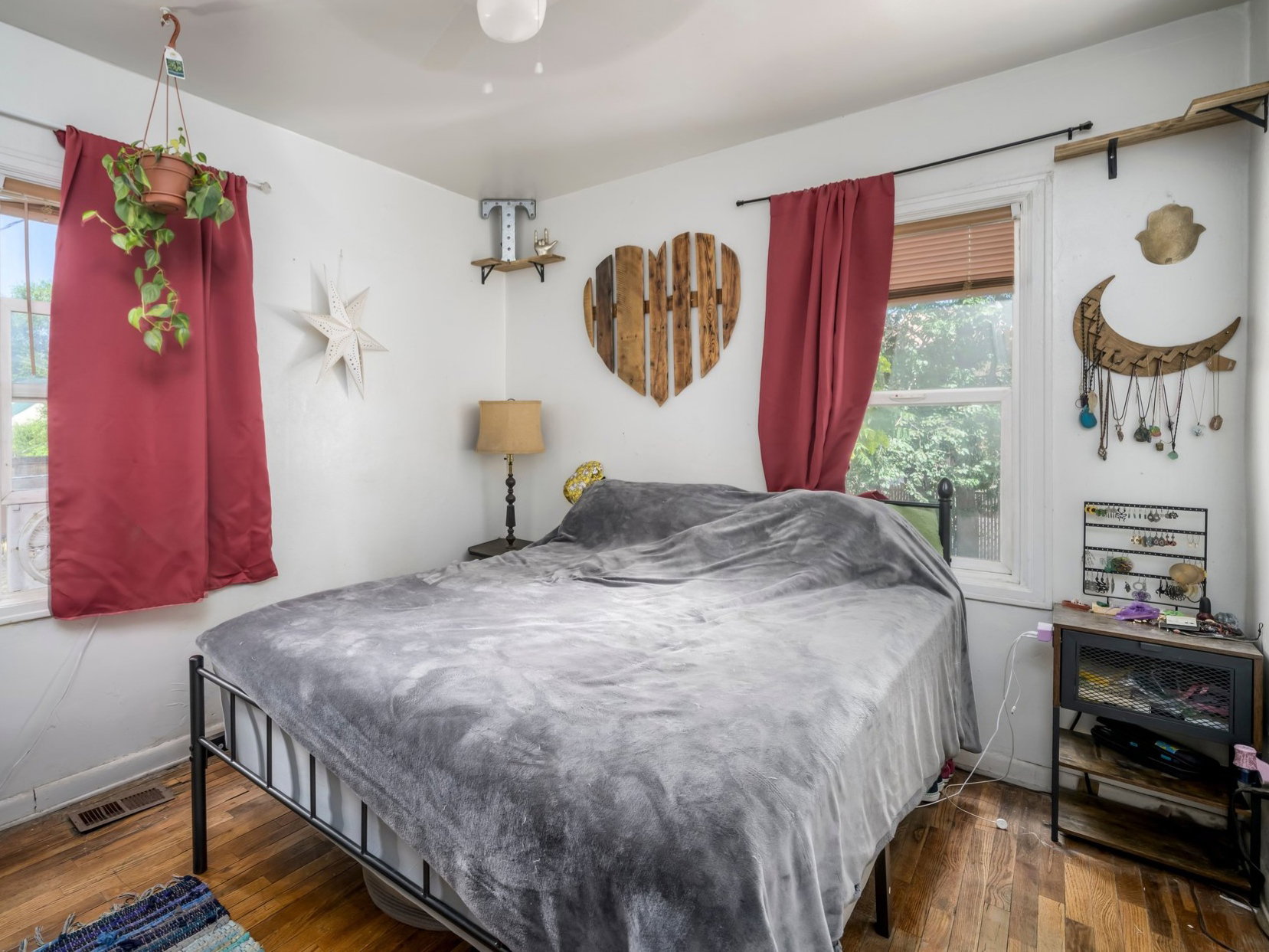 Bedroom featuring wood-finish flooring, two windows, and a ceiling-mounted light fixture