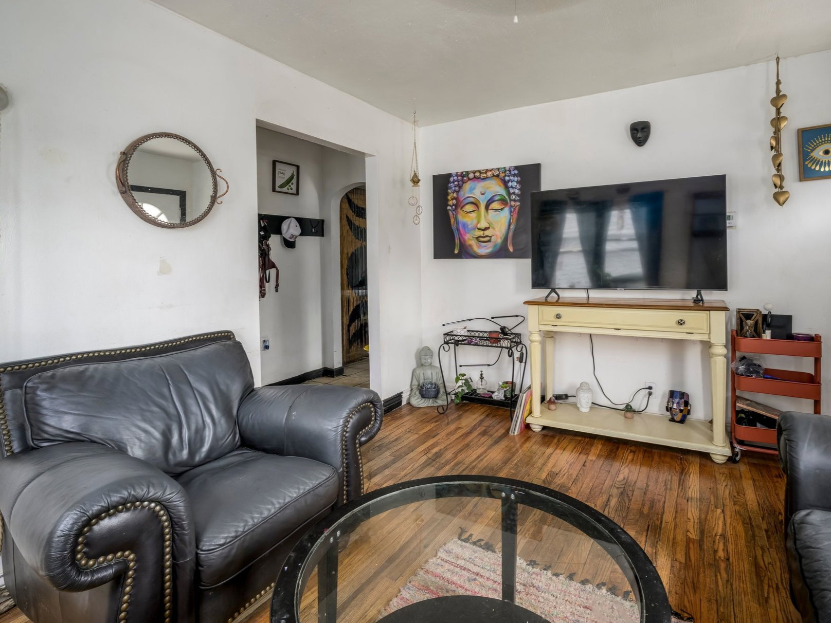 Living area featuring wood-finish flooring, white walls, and a ceiling-mounted light fixture