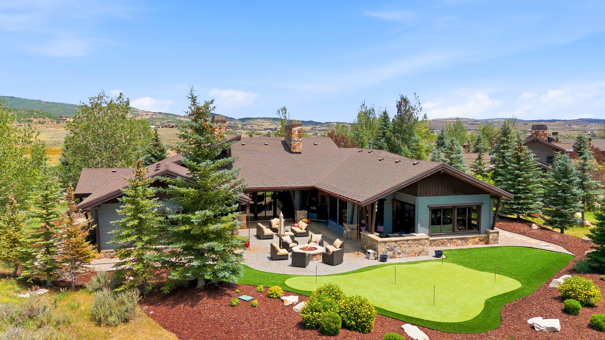 Expansive rear patio featuring a putting green, paved patio, and covered outdoor living space