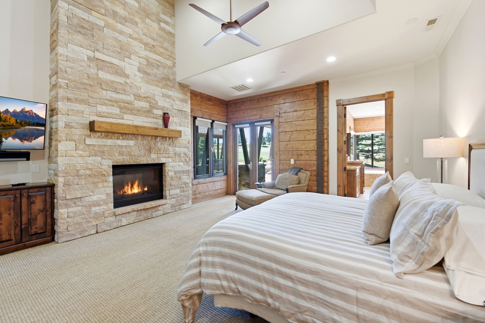 Floor-to-ceiling stone fireplace featuring a wood mantel