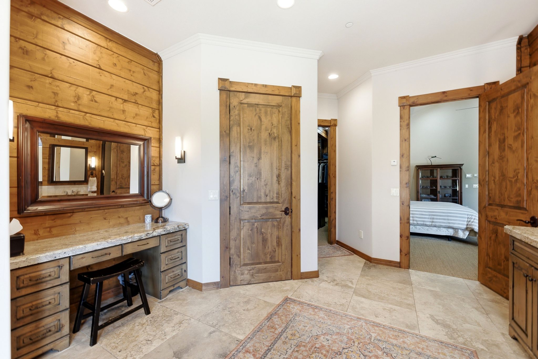 Vanity area featuring wood paneling, a framed mirror, and a stone-look countertop with integrated cabinetry