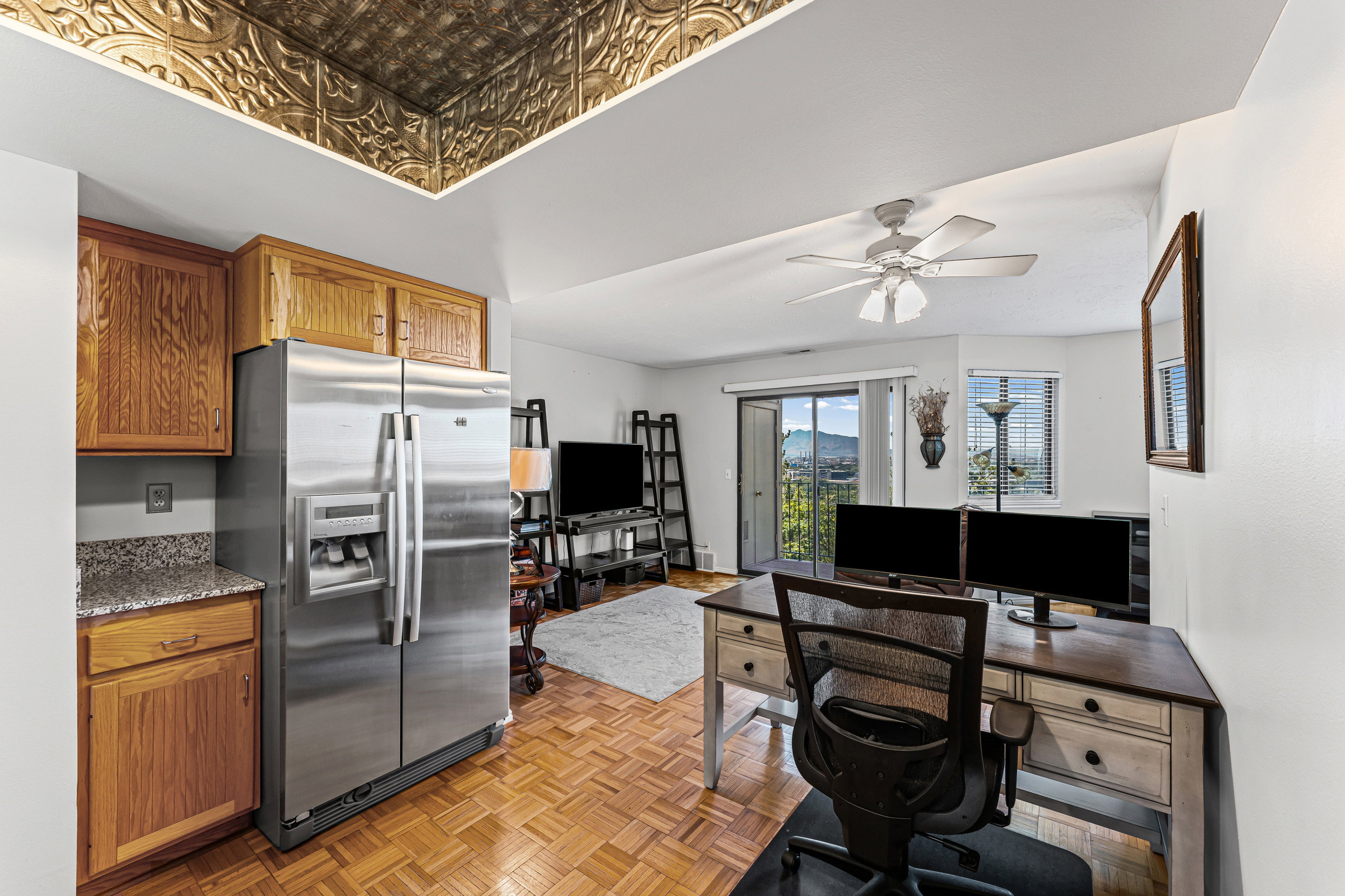 Kitchen area with wood cabinetry and a stainless steel refrigerator