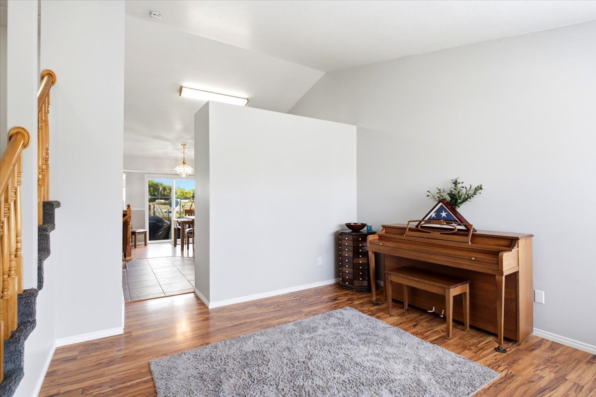 Entryway featuring wood-finish flooring, light gray wall tones, and a staircase with a wooden banister and carpeted treads