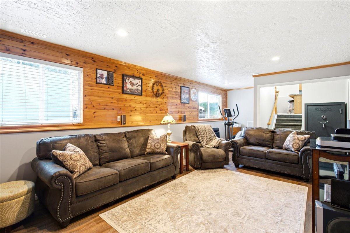 Recreation space featuring wood-paneled accent wall, neutral paint, recessed lighting, and wood-finish flooring