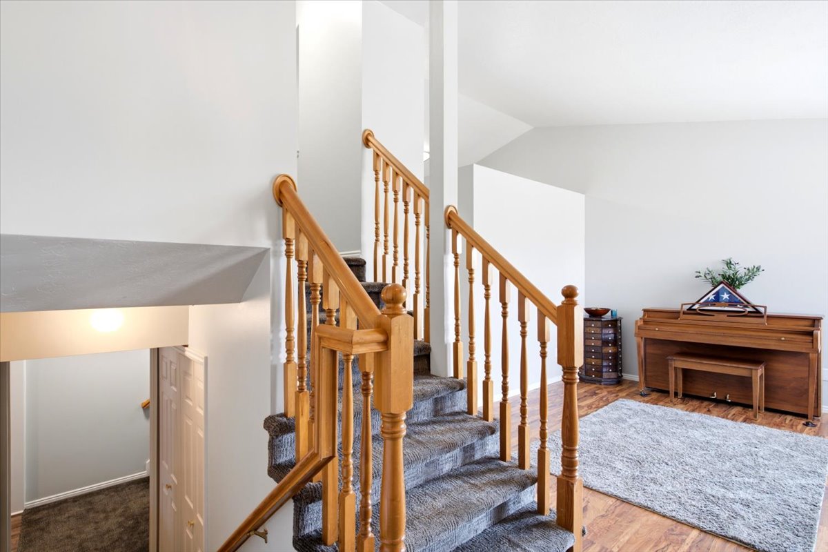 Carpeted staircase with wood-finish handrails and spindles