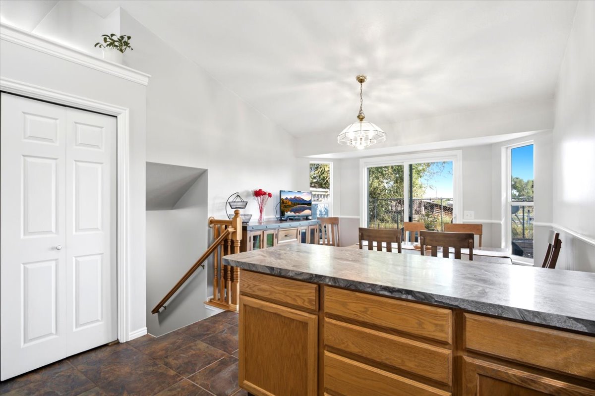 Kitchen island with stone-finish countertop and light wood cabinetry