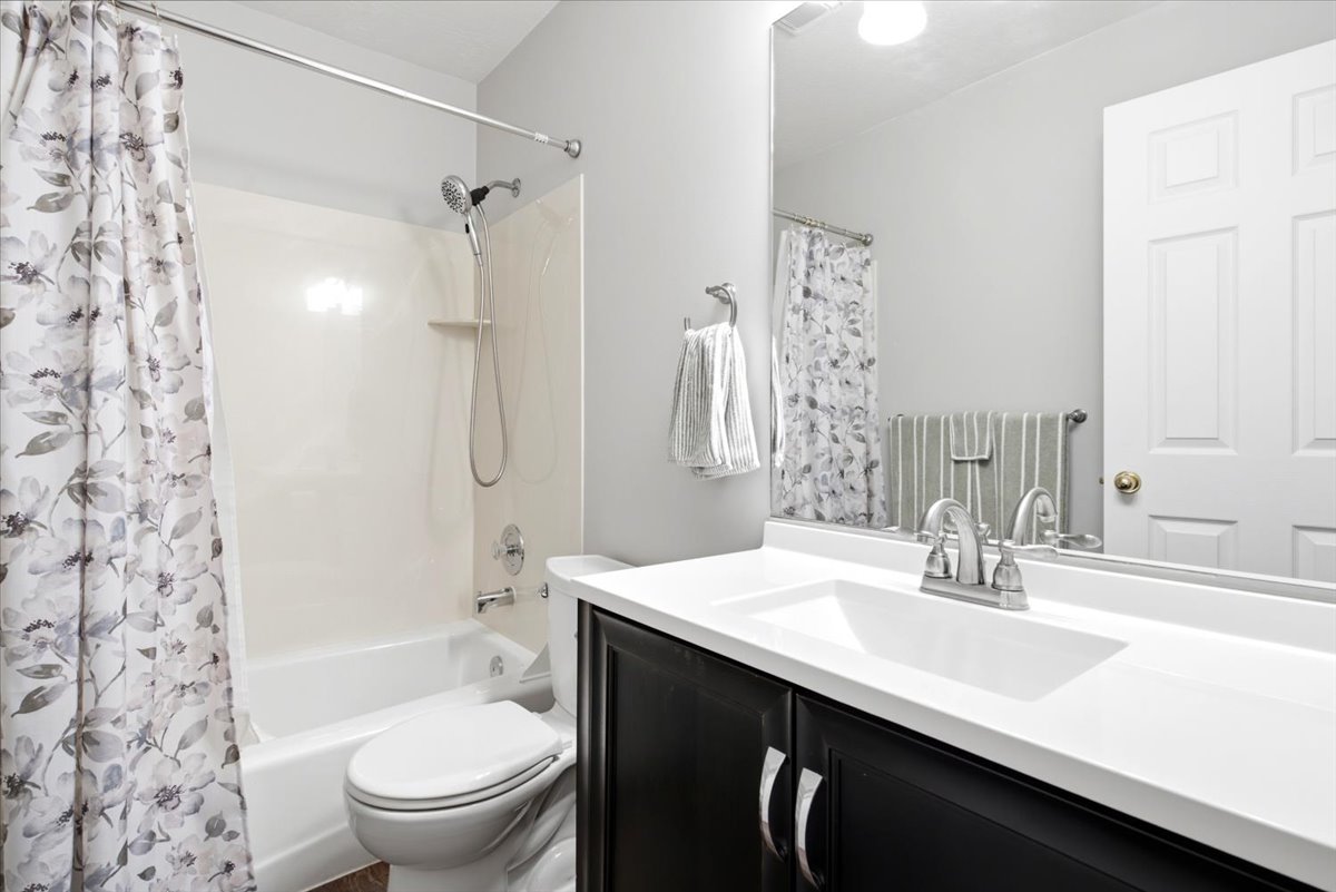 Bathroom vanity with an integrated sink, brushed nickel faucet, and dark wood-finish cabinetry